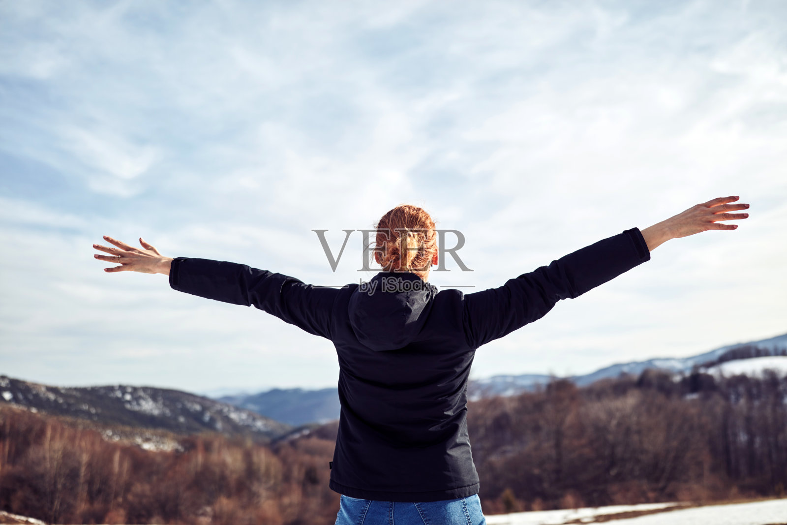 女人在山上享受冬天的新鲜空气。照片摄影图片