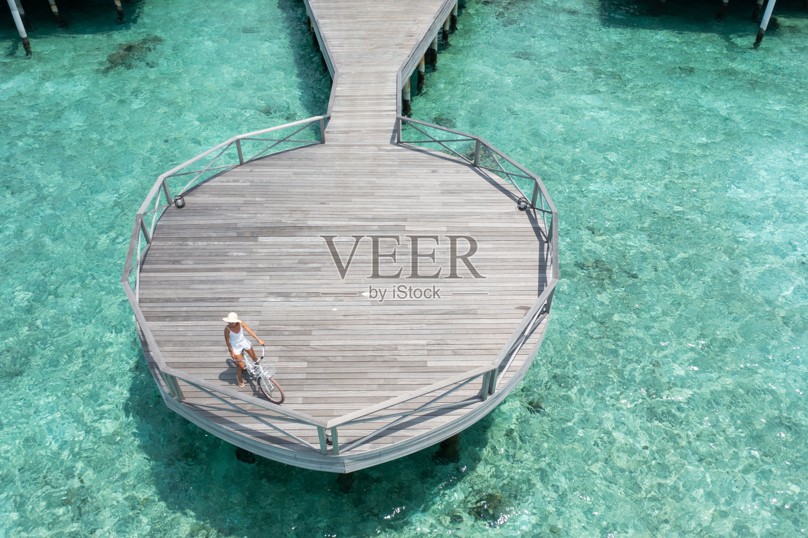 一名女子在马尔代夫的木码头上骑自行车照片摄影图片