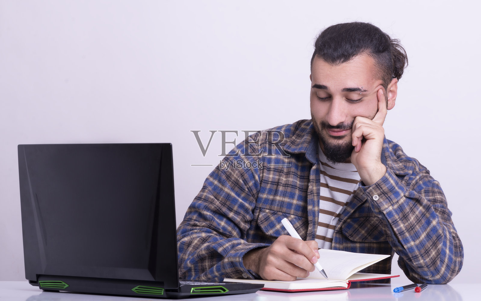 快乐的年轻商人记笔记。照片摄影图片