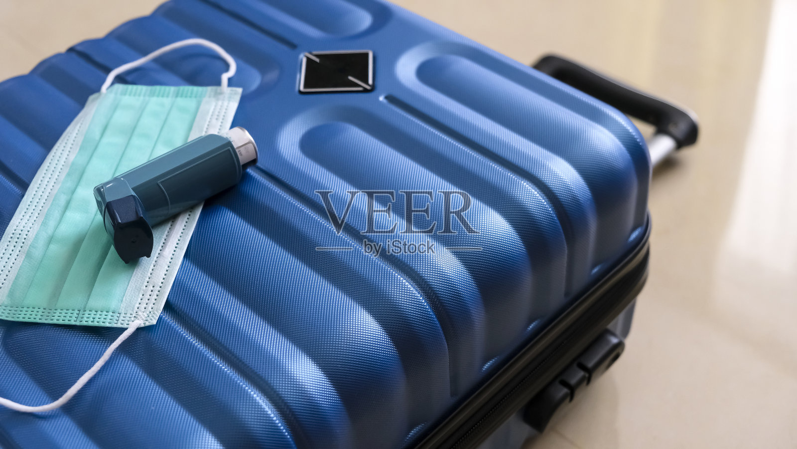 covid - 19大流行期间旅行所需的行李箱、口罩和吸入器齐全。概念假期和旅行。横幅的尺寸。复制空间，选择性聚焦。浅景深照片摄影图片