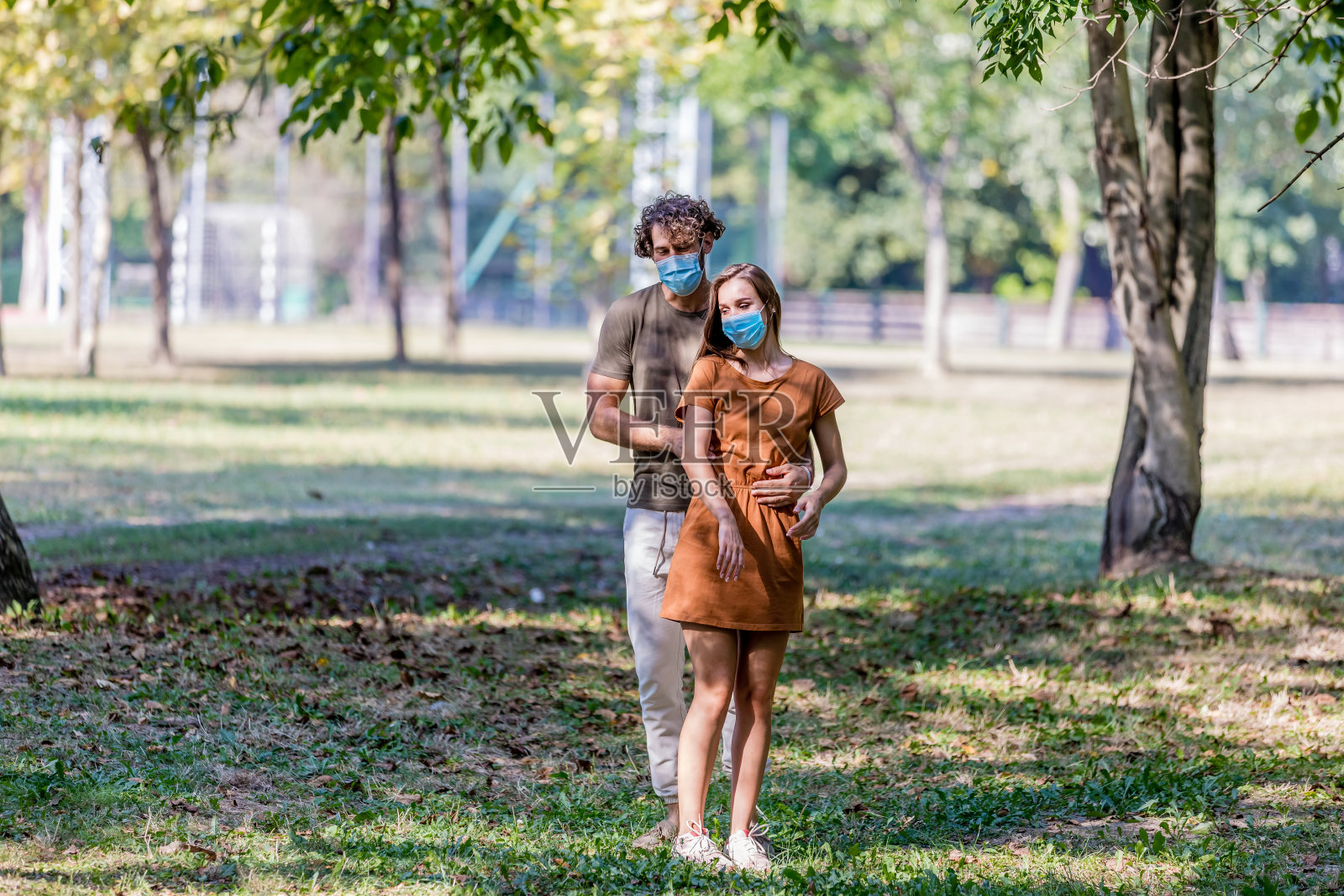 大流行期间，情侣在公园散步，享受秋日午后。照片摄影图片