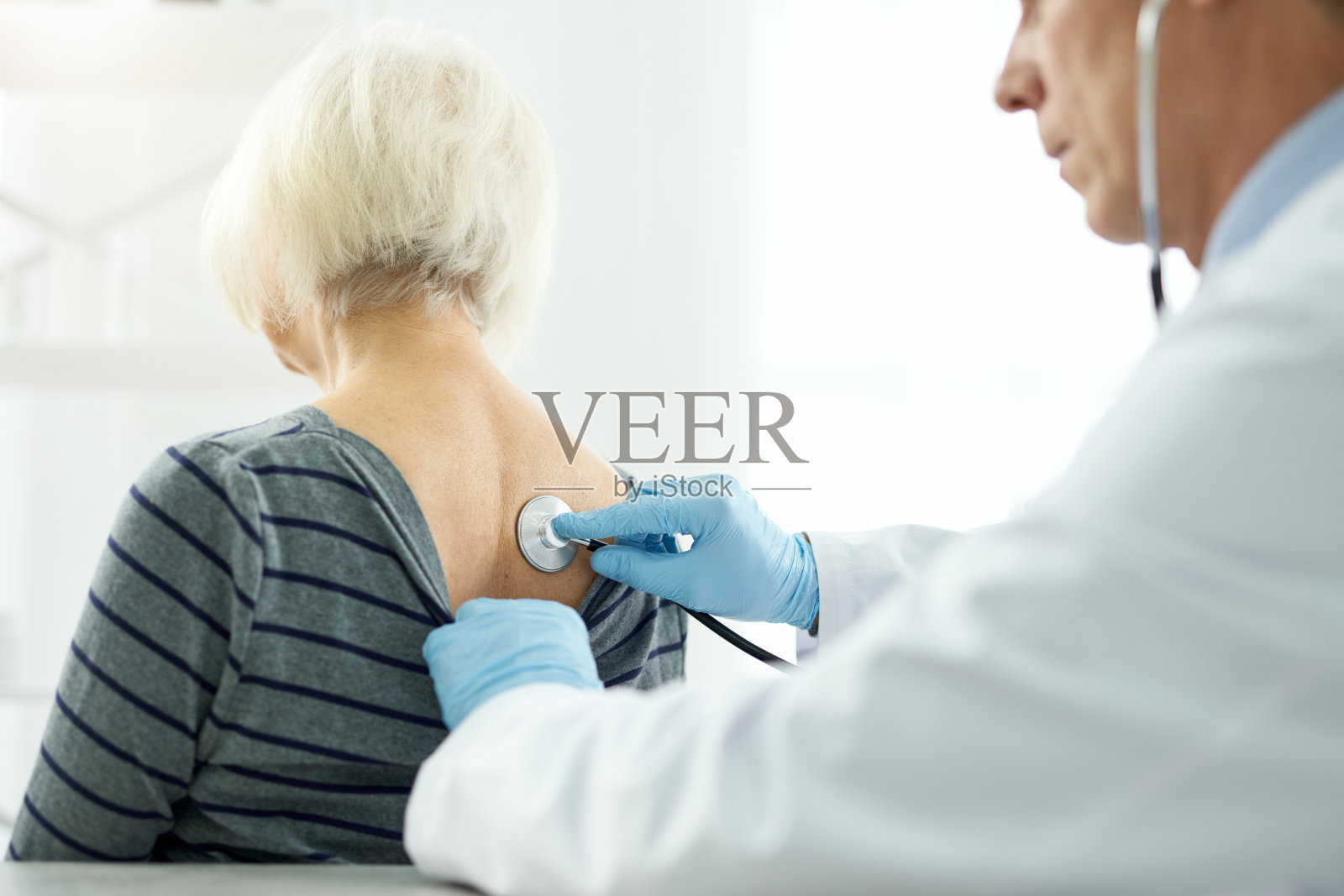 医生在门诊用听诊器检查女患者照片摄影图片