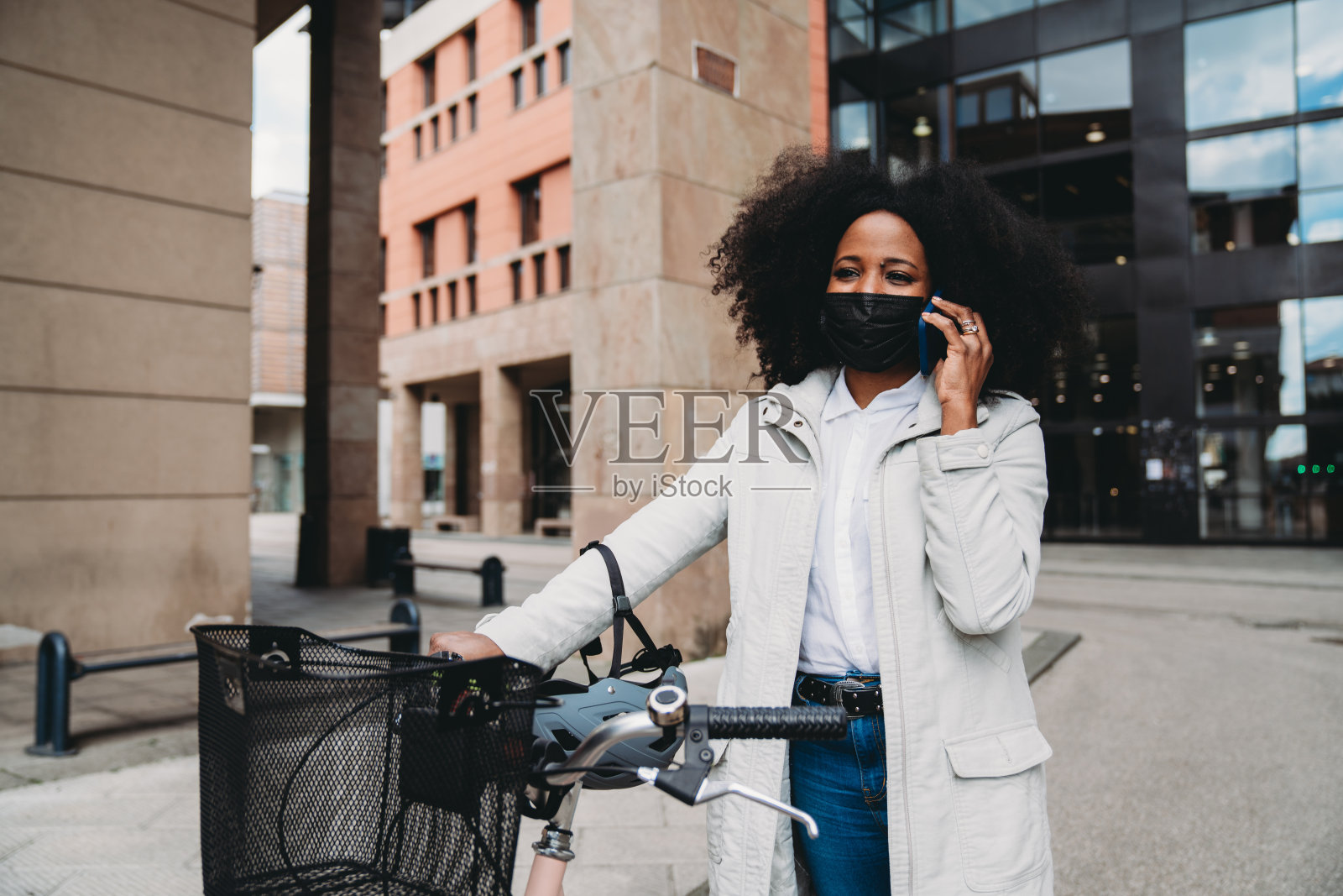 女商人在阳光明媚的日子骑自行车上班，用智能手机打电话照片摄影图片