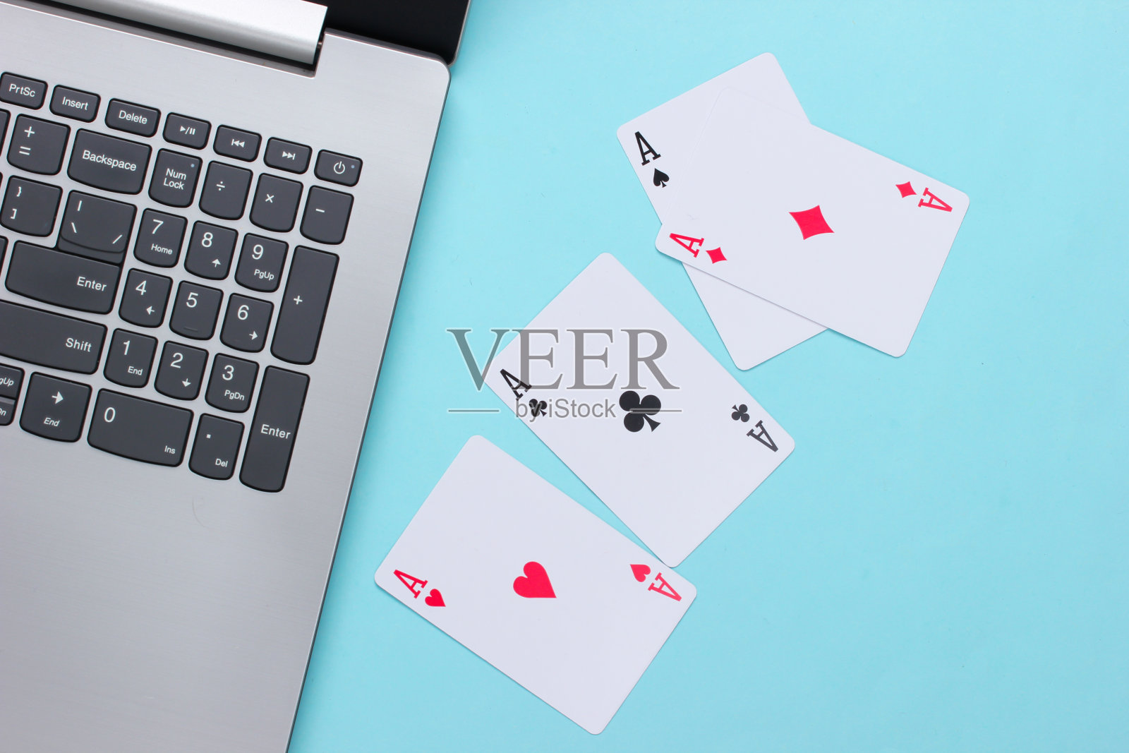 四个a，蓝色背景的笔记本电脑键盘。在线扑克赌场。游戏成瘾照片摄影图片