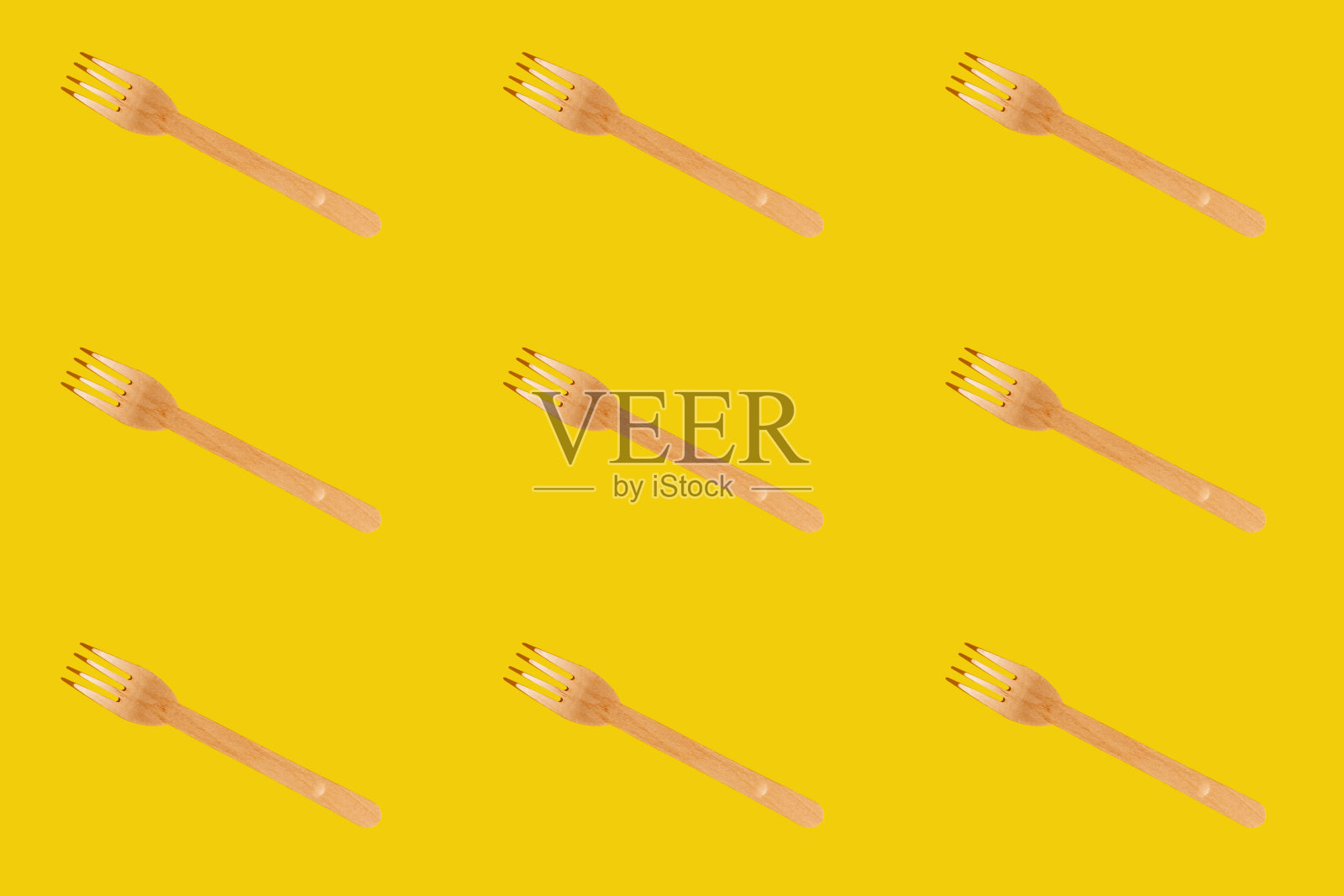 木制的棕色一次性餐具。叉的模式。背景是黄色的。照片摄影图片