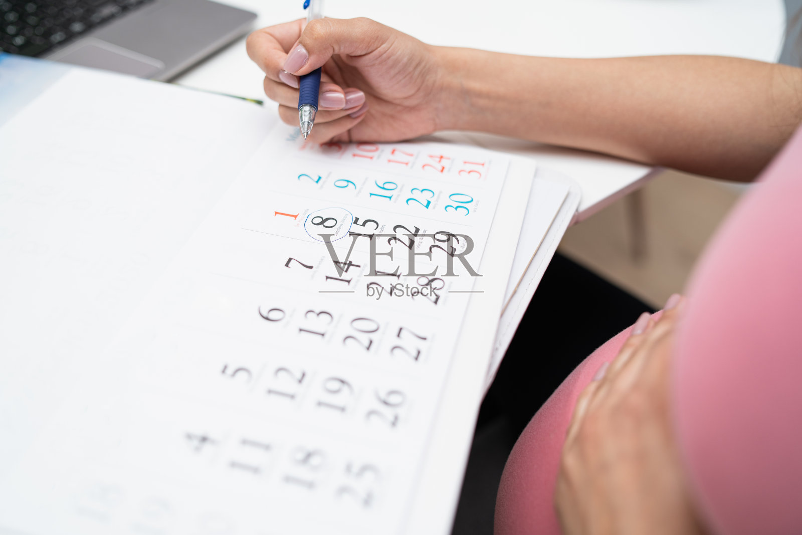 孕妇在日历上标明出生日期照片摄影图片