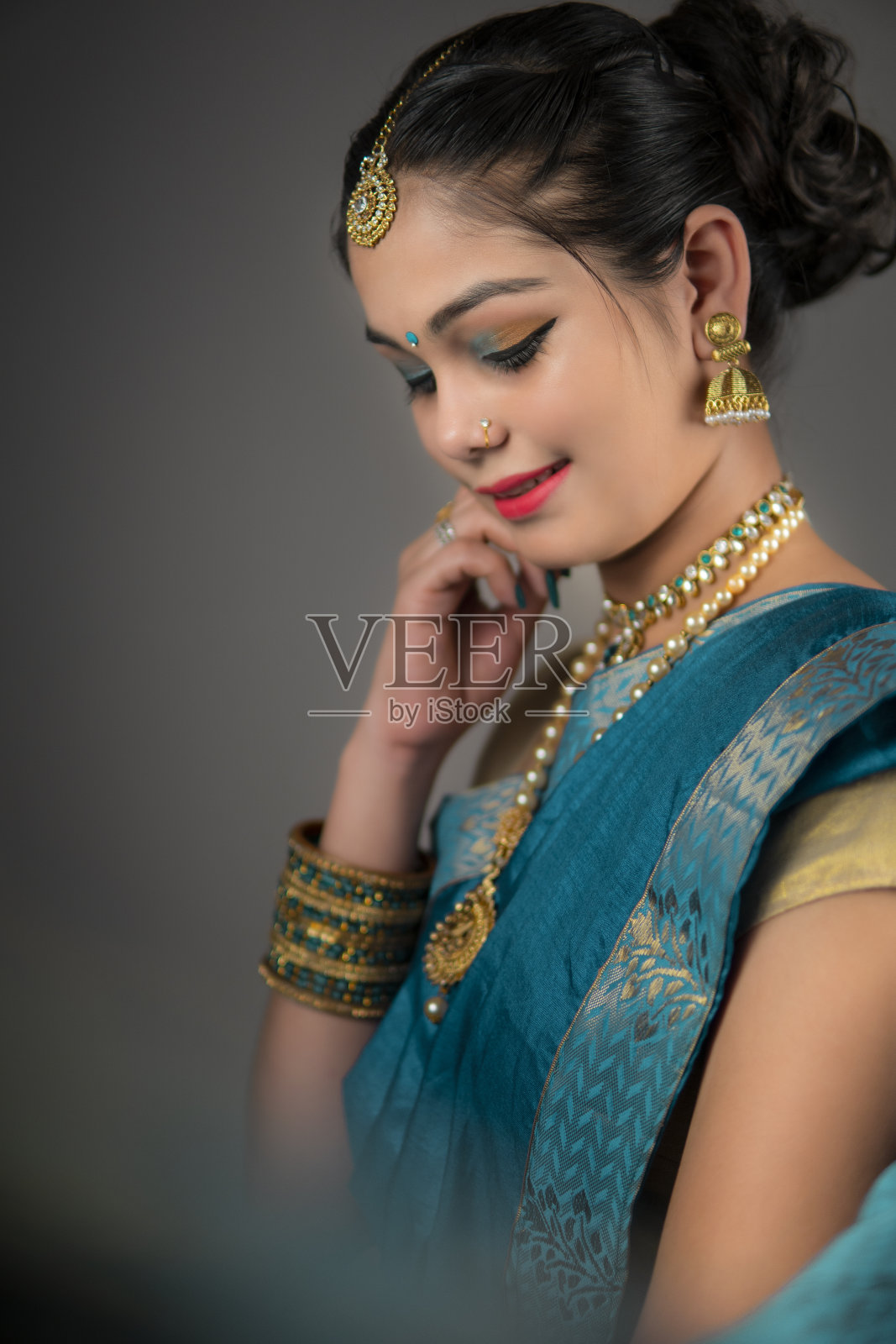 肖像美丽，害羞的女人在传统印度纱丽和珠宝。照片摄影图片