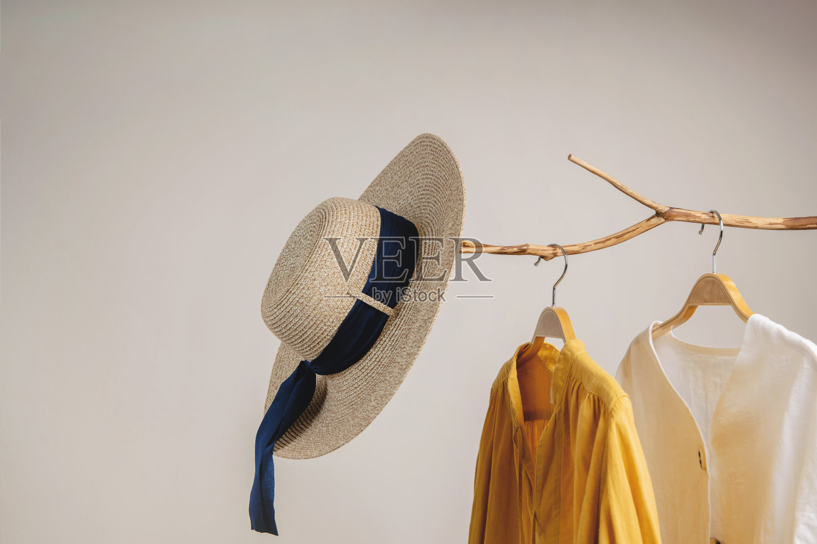 衣服的概念。妇女穿挂在干树枝上的衣服。白墙上的阴影照片摄影图片