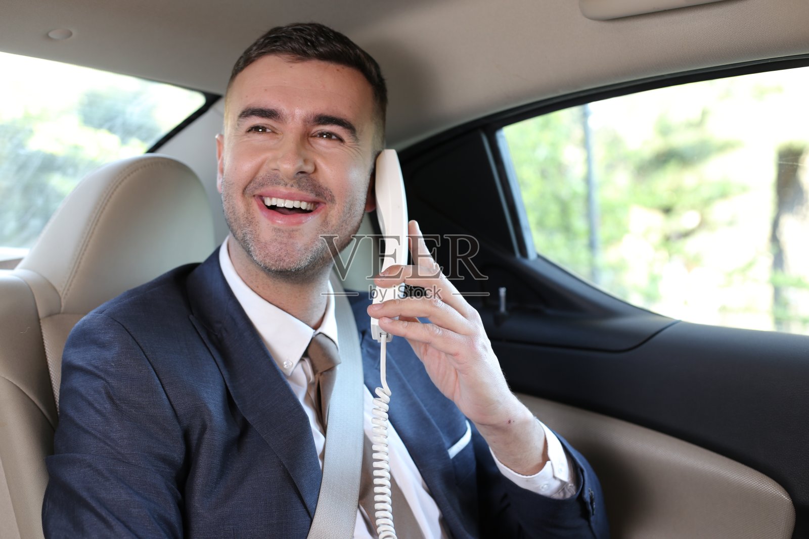 在豪华轿车中使用固定电话的商人照片摄影图片