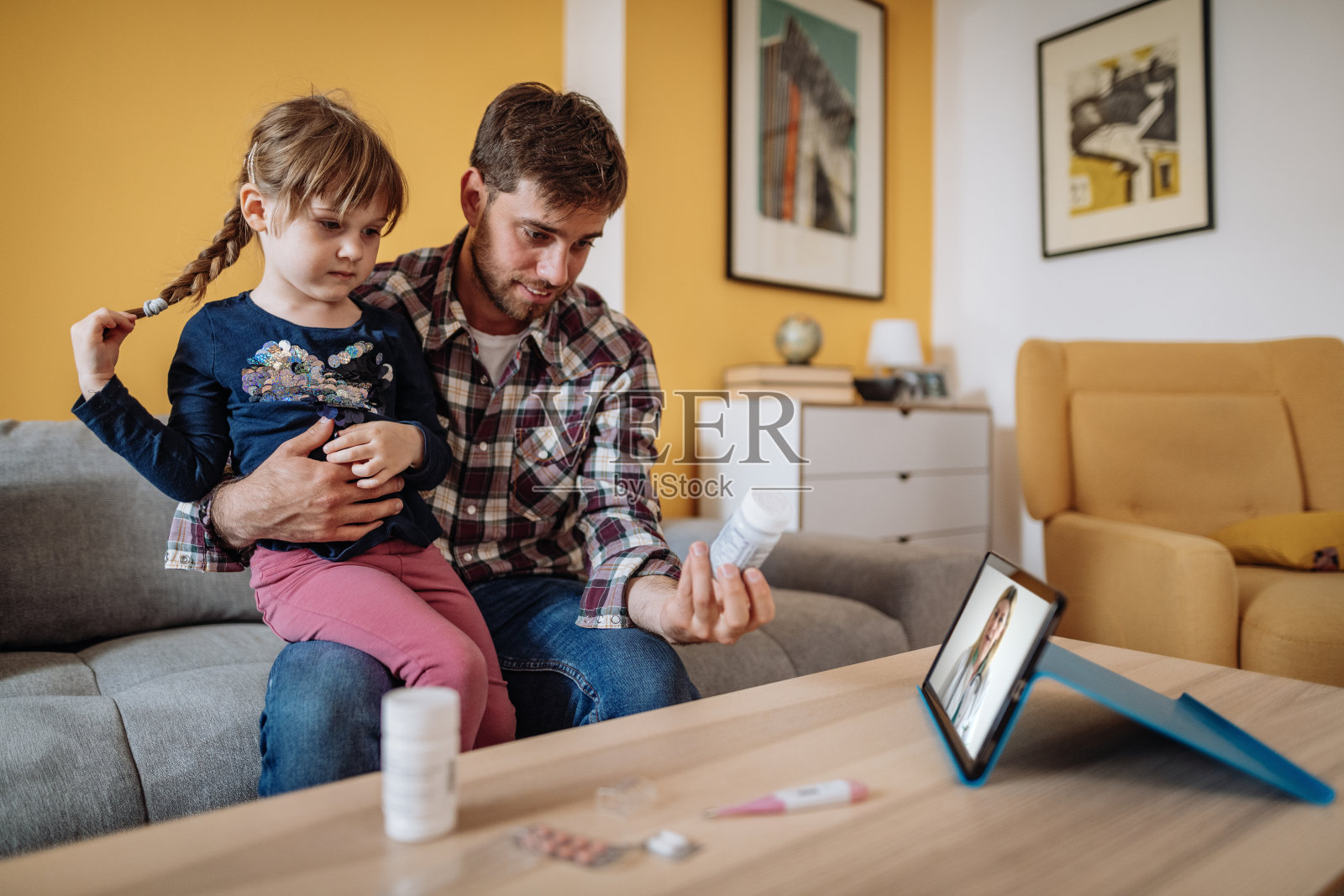 冠状病毒大流行期间的远程医疗——父亲和女儿与医生进行在线医疗检查照片摄影图片