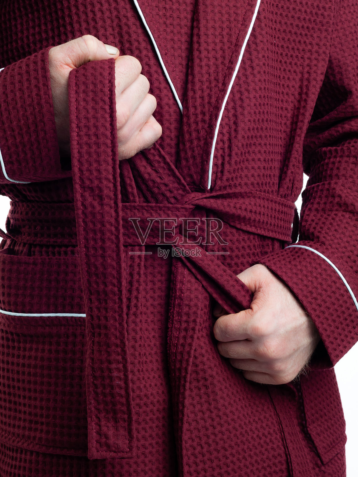 一个穿着明亮的浴袍的男人在一个孤立的白色背景上为服装细节做广告。照片摄影图片