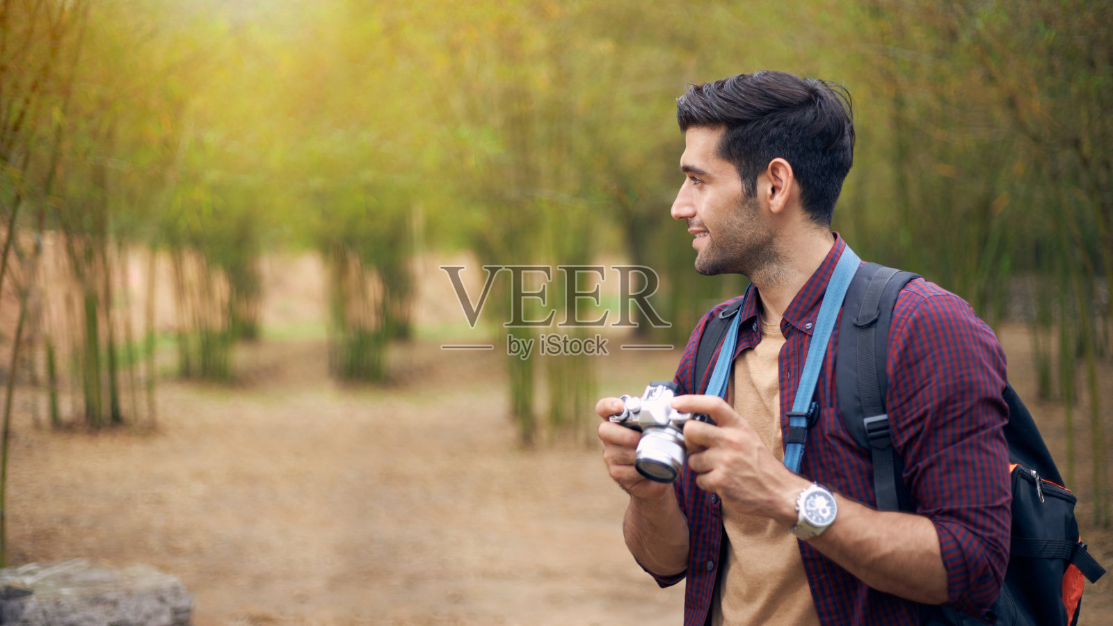 手持数码相机的白人男性游客。照片摄影图片