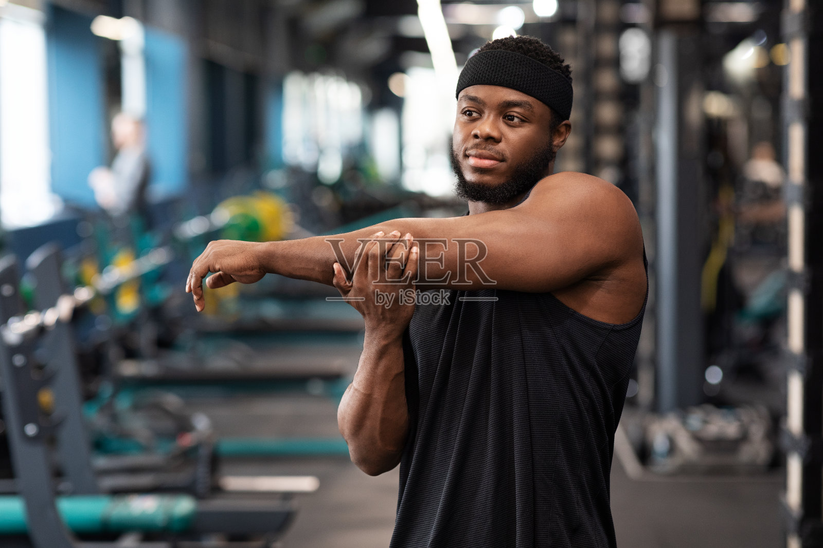 黑人运动员在健身房锻炼前伸展肌肉照片摄影图片
