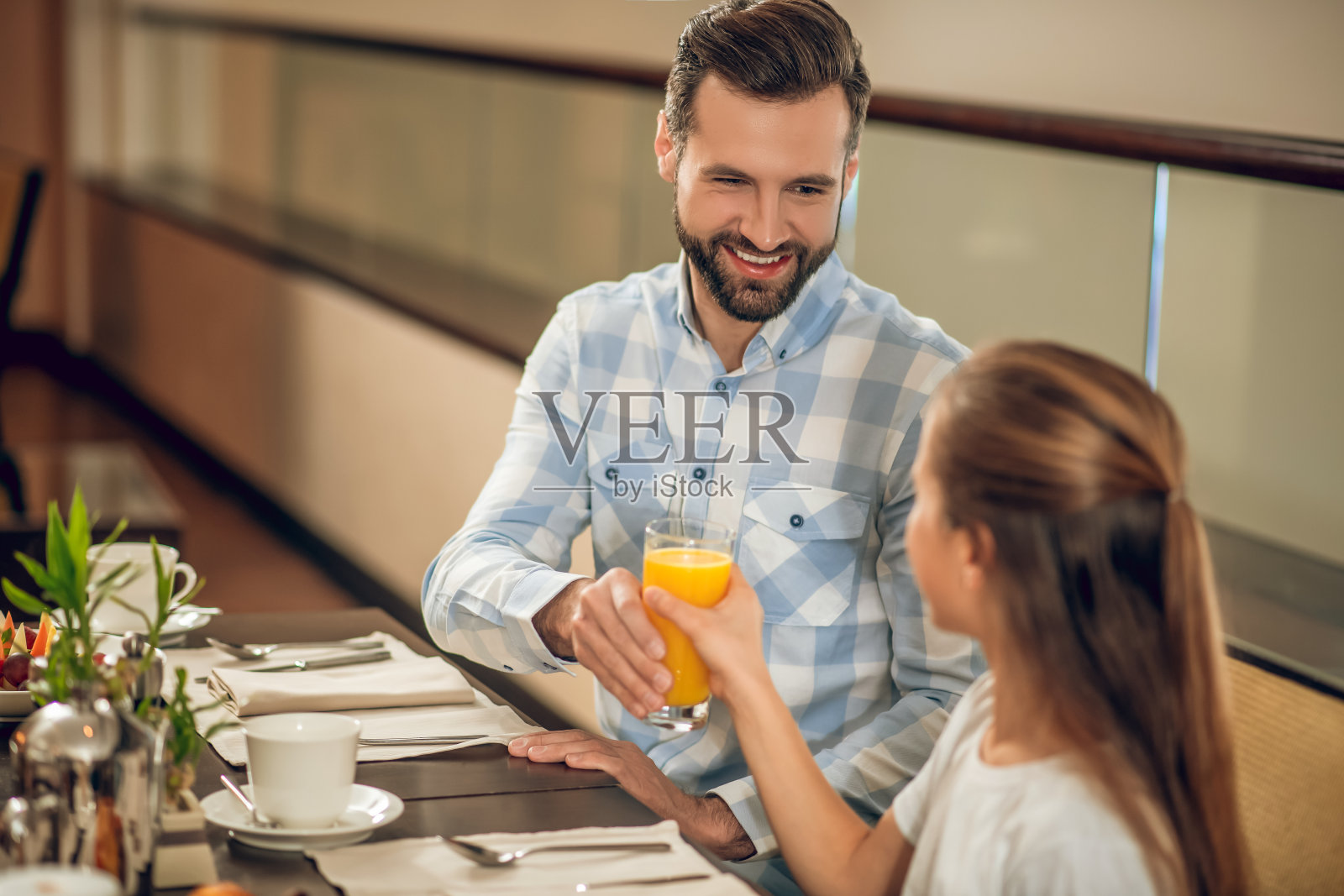 孩子们和他们的爸爸坐在餐厅的桌子旁照片摄影图片