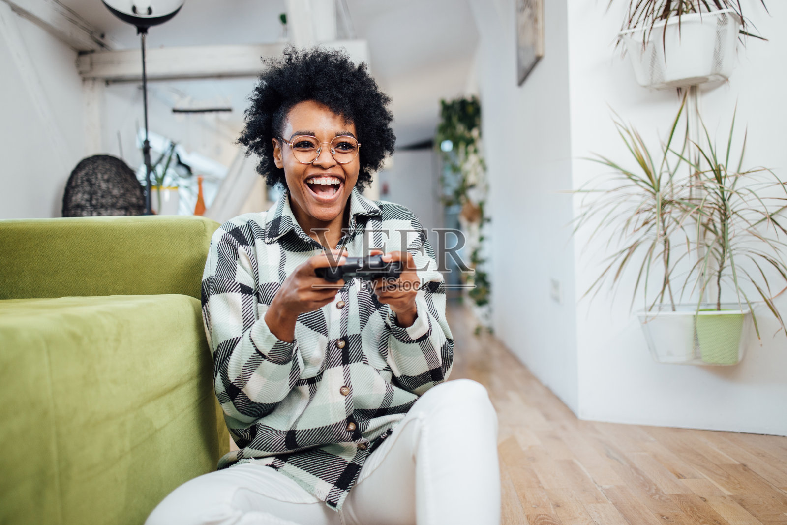 一个在家里玩游戏的非裔美国女人照片摄影图片