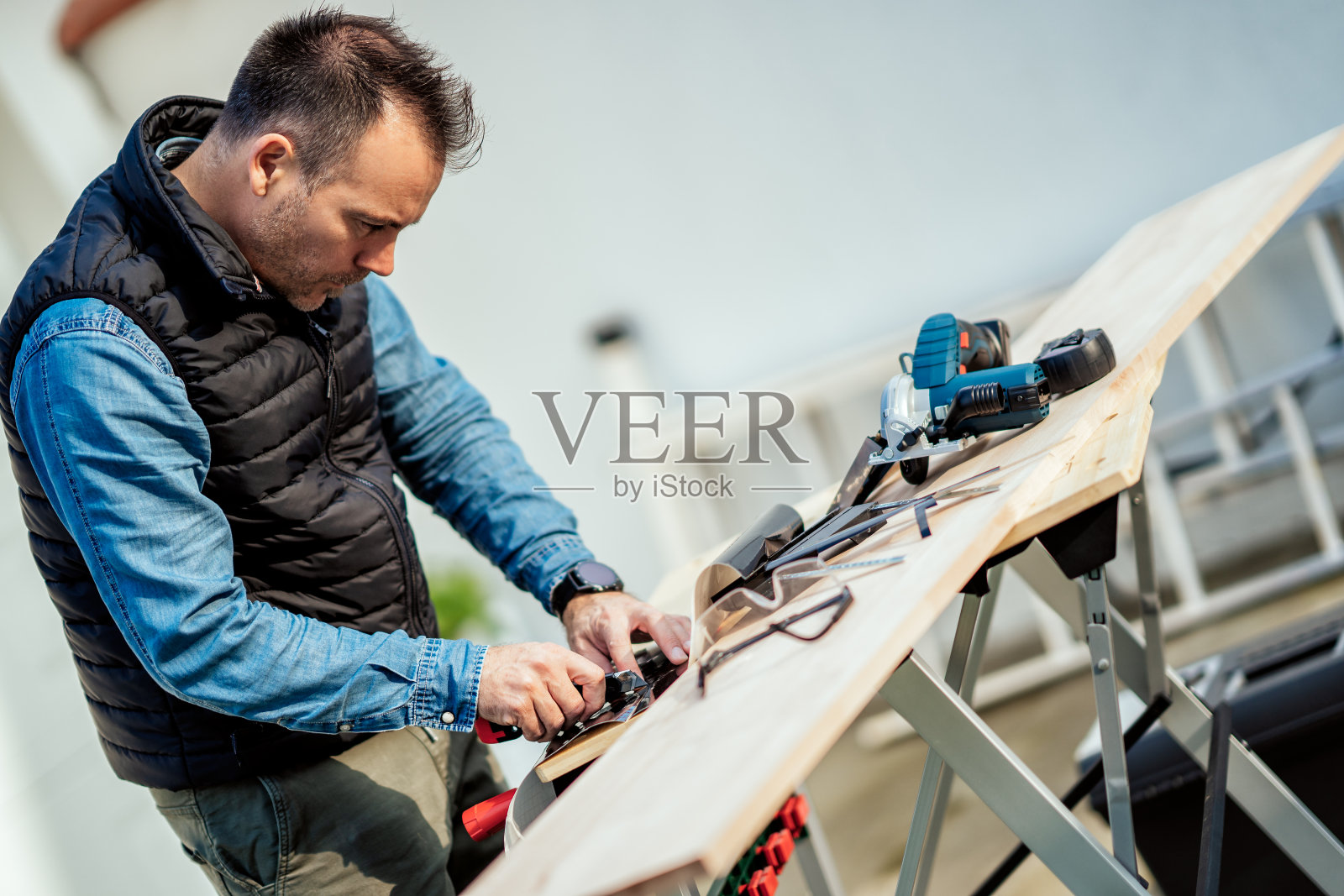 一个男人在后院的木桌上操作设备照片摄影图片