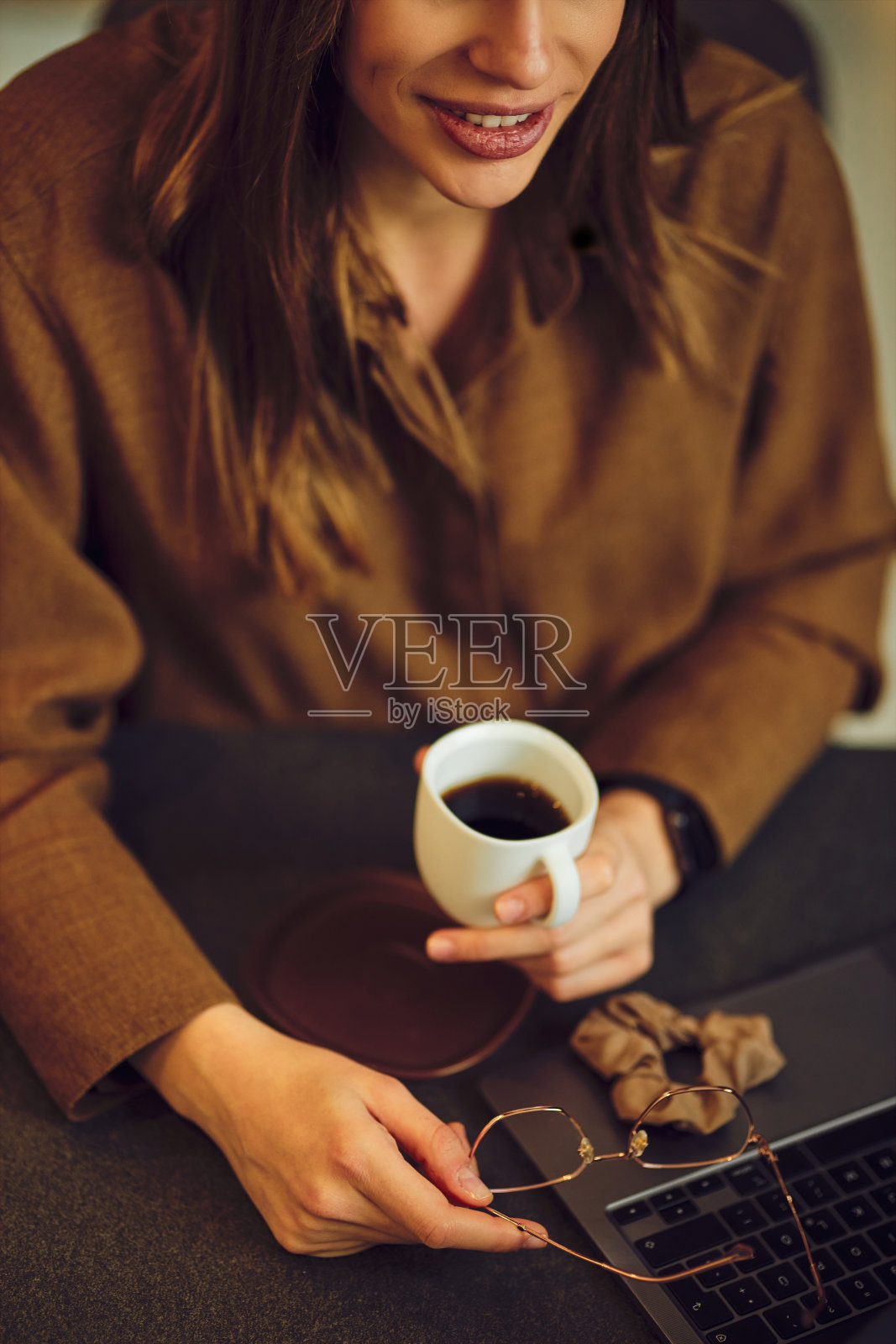 俯视图的手拿着眼镜和咖啡。照片摄影图片