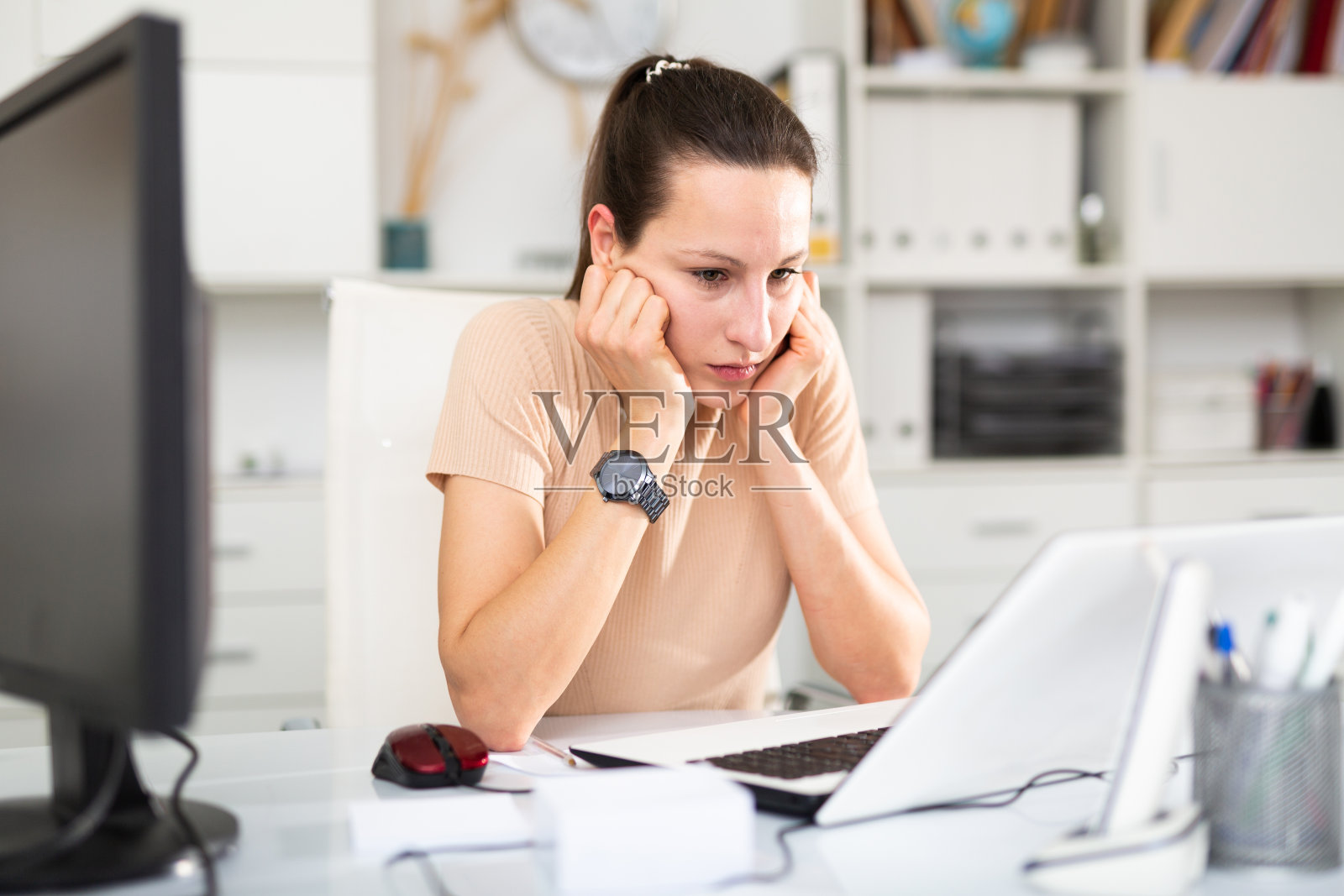 疲惫的女商人在办公室的桌子上处理文件照片摄影图片