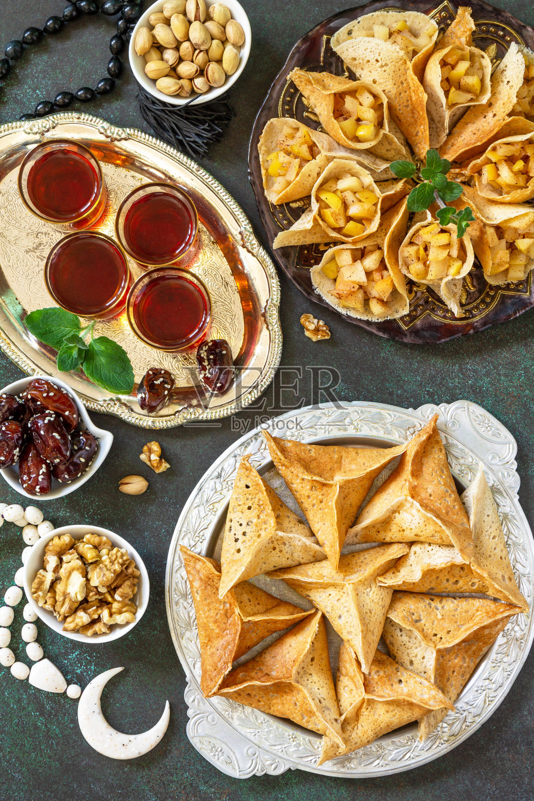 阿拉伯菜。斋月Kareem节日。斋月菜单，埃及东方甜点:什锦阿拉伯煎饼，椰枣，开心果。前视图。照片摄影图片