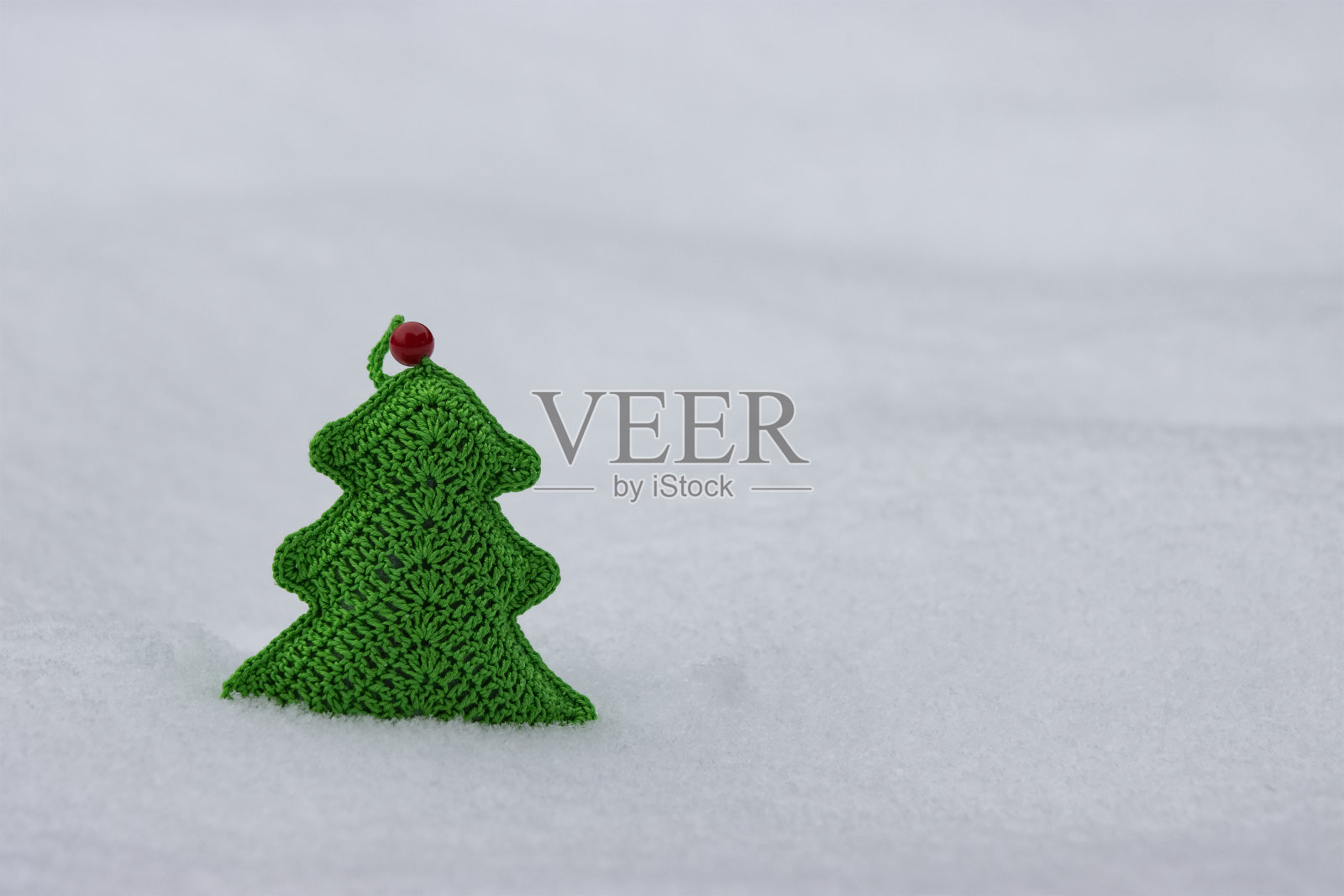 用绿线做成圣诞树形状的玩具。照片摄影图片