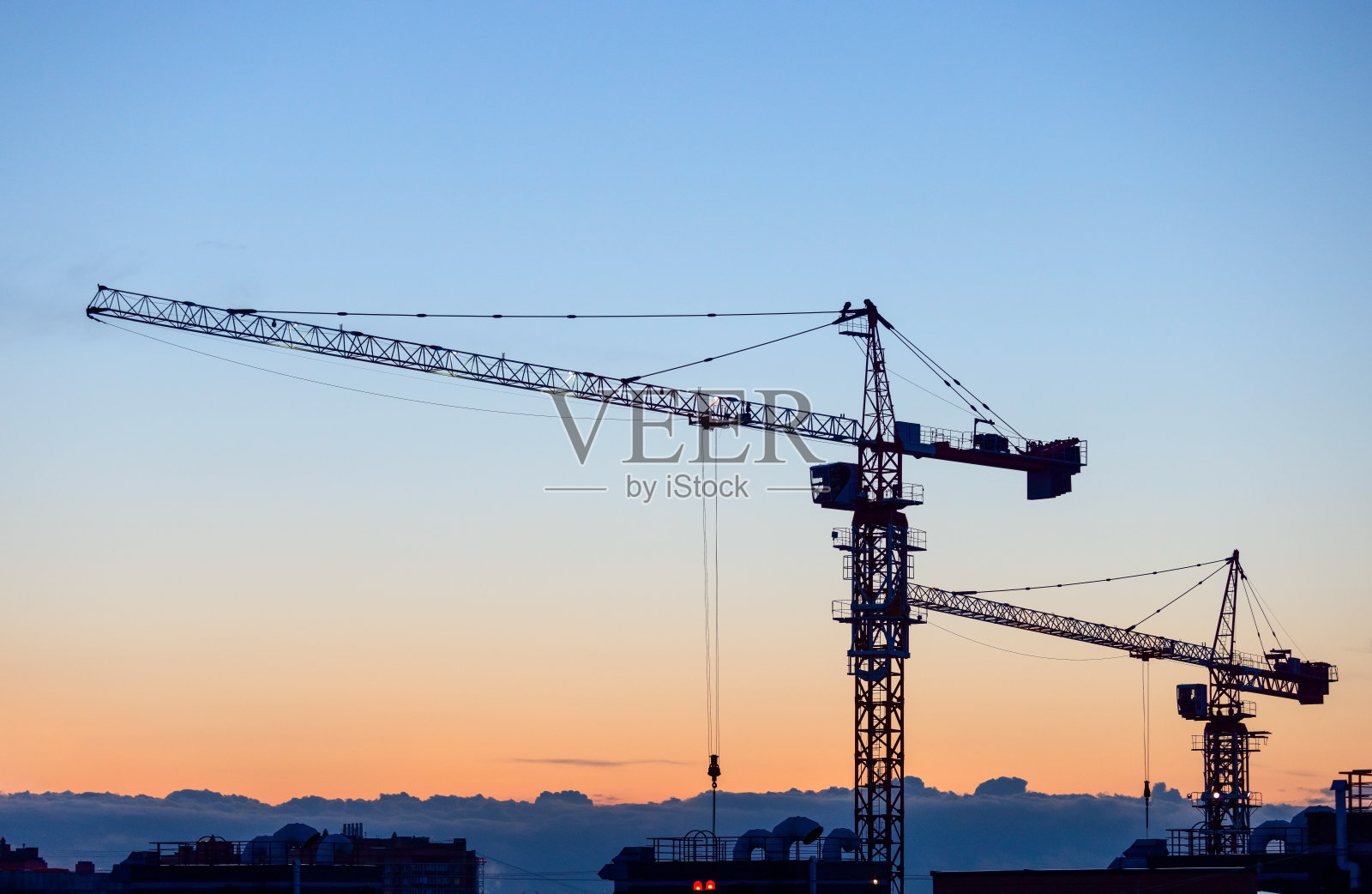 日落时分，建筑工地上塔吊的剪影照片摄影图片