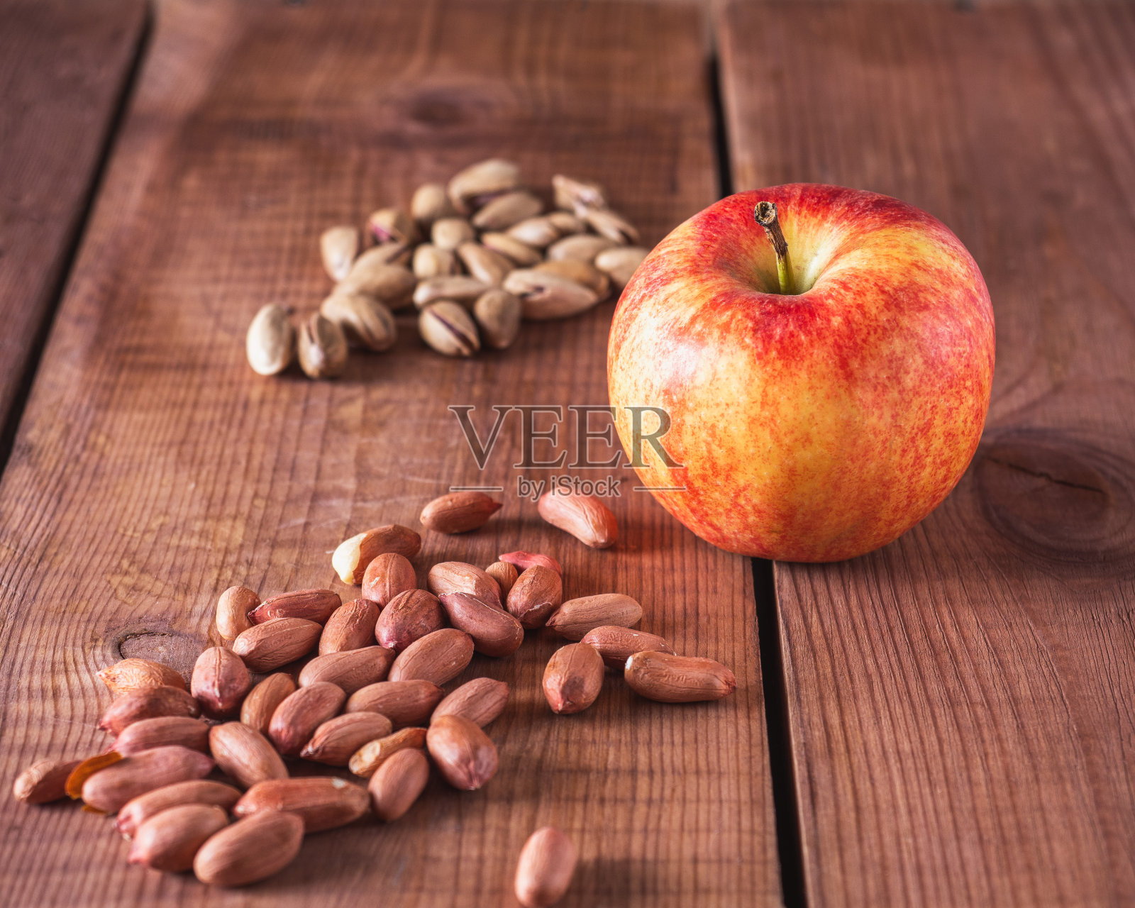 撒点花生，开心果和一个红苹果照片摄影图片