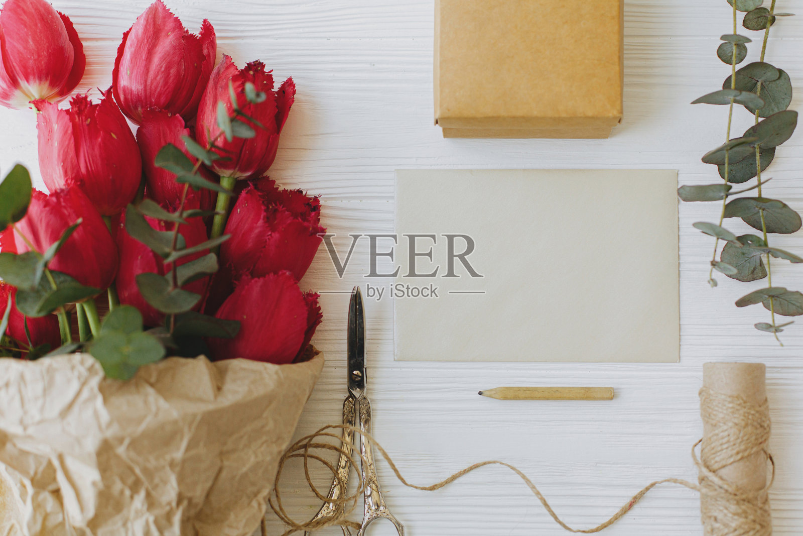 快乐的母亲节。红色郁金香与贺卡，礼物，铅笔，剪刀在乡村木材平躺照片摄影图片