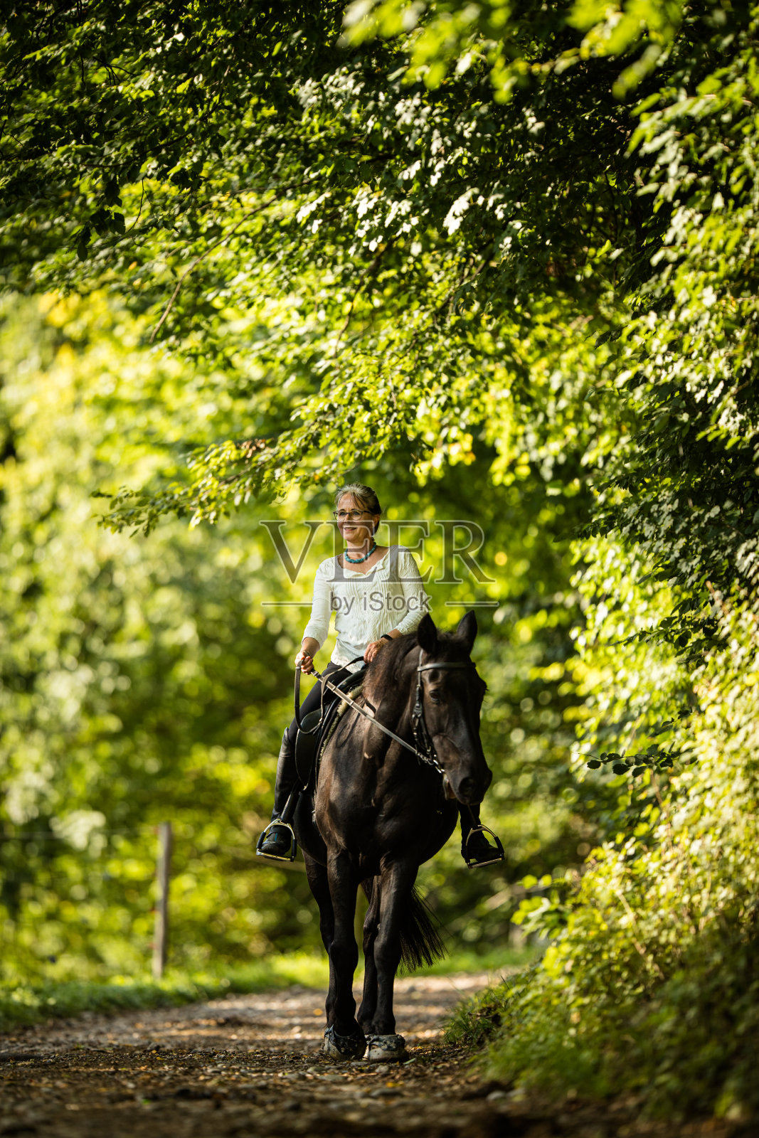 骑马的女人。照片摄影图片