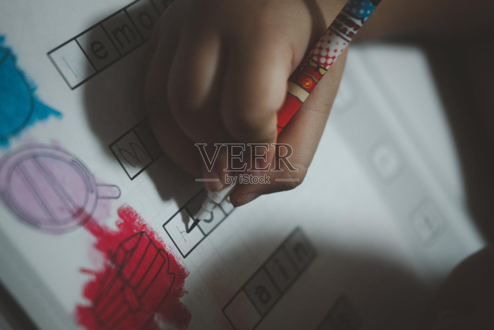 小男孩用桌上的铅笔在纸上写字。练习写作的概念照片摄影图片