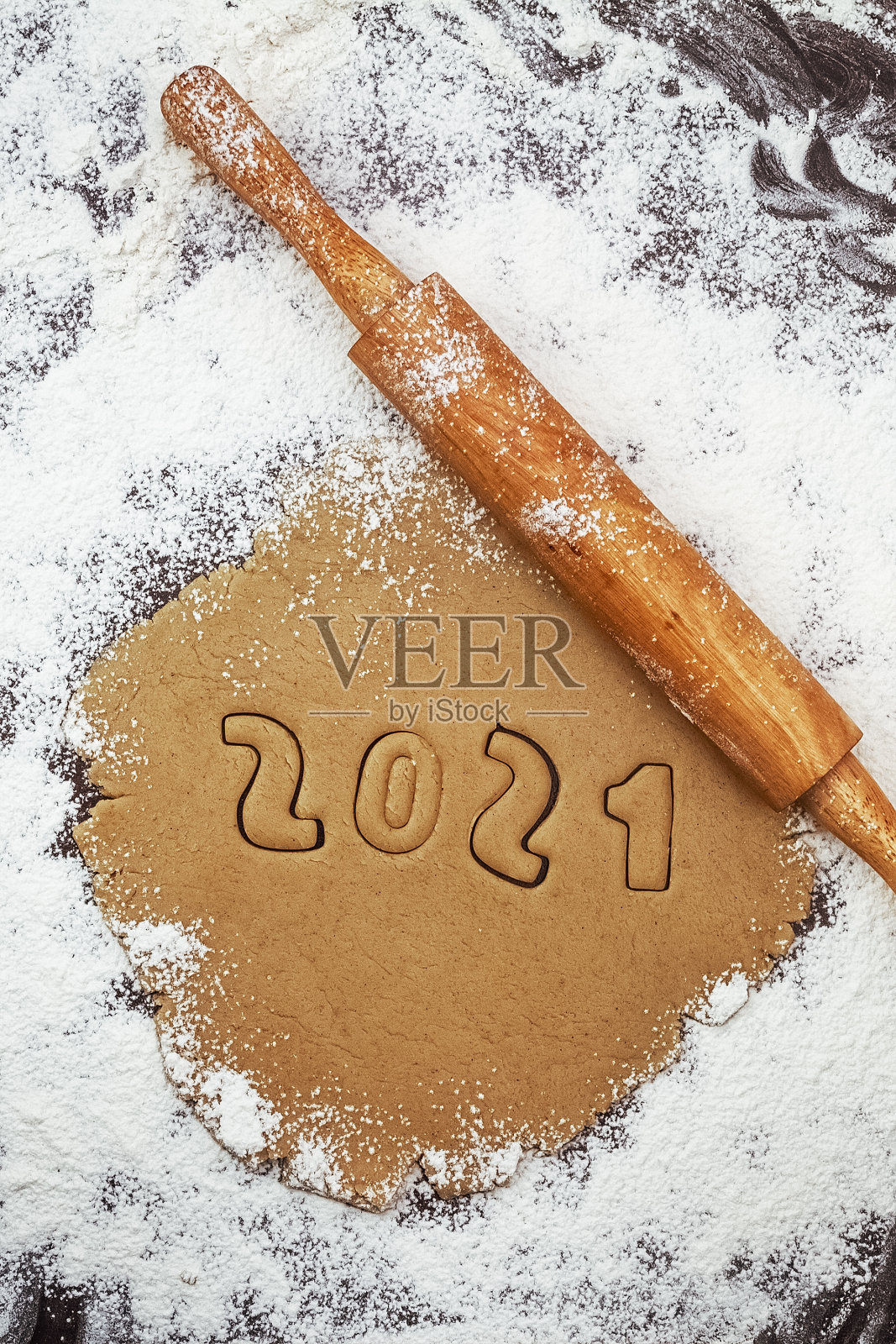 在面粉和擀面杖上，2021年的数字从生饼干生面团中削减照片摄影图片