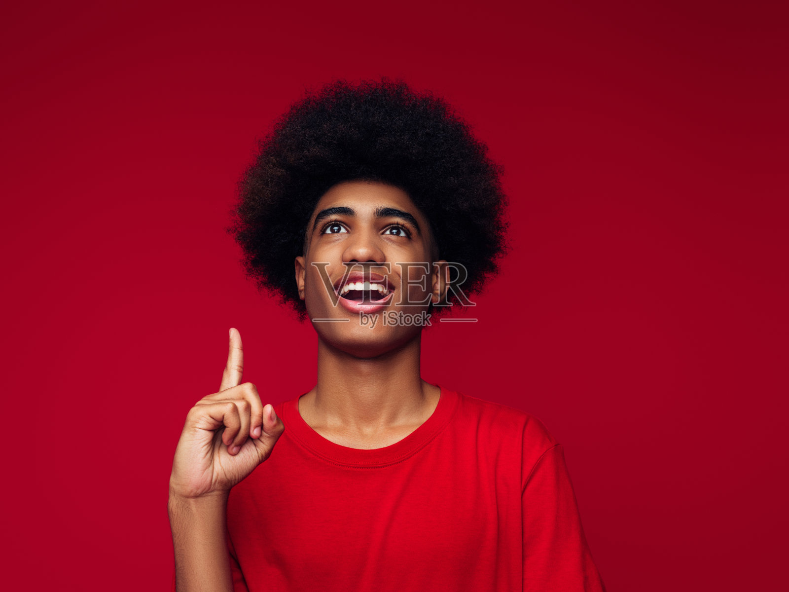 非裔美国人与非洲发型穿着帽衫站在孤立的红色背景照片摄影图片