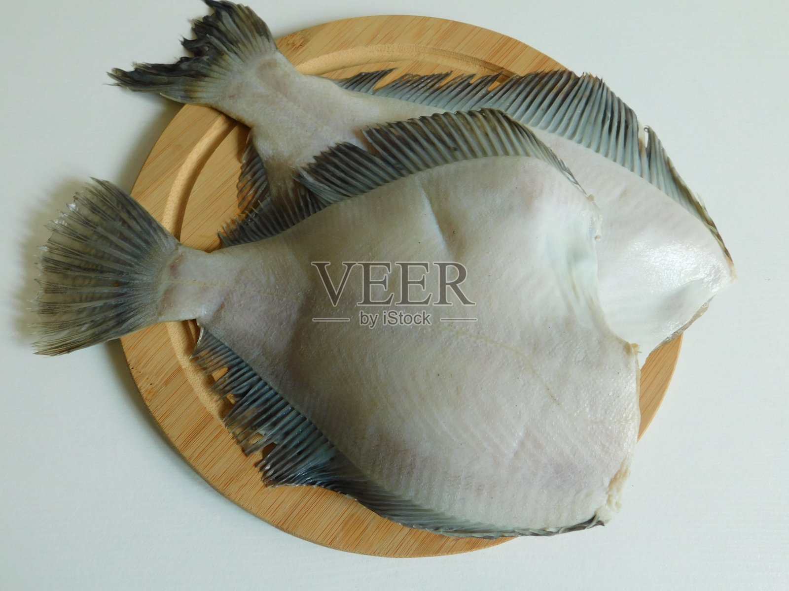 两道新鲜比目鱼，大小不一。照片摄影图片