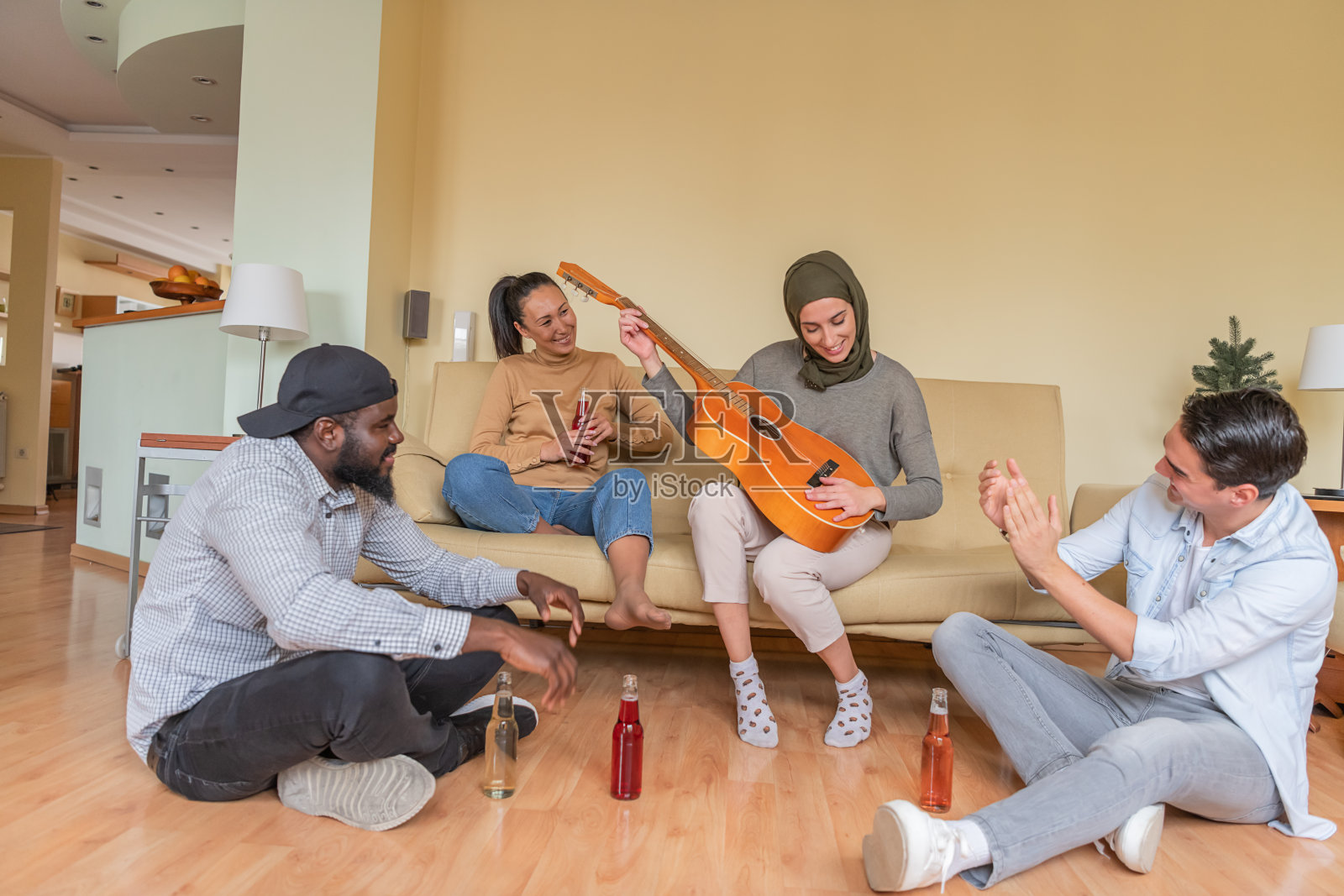一群快乐的年轻朋友在吉他声中享用饮品照片摄影图片