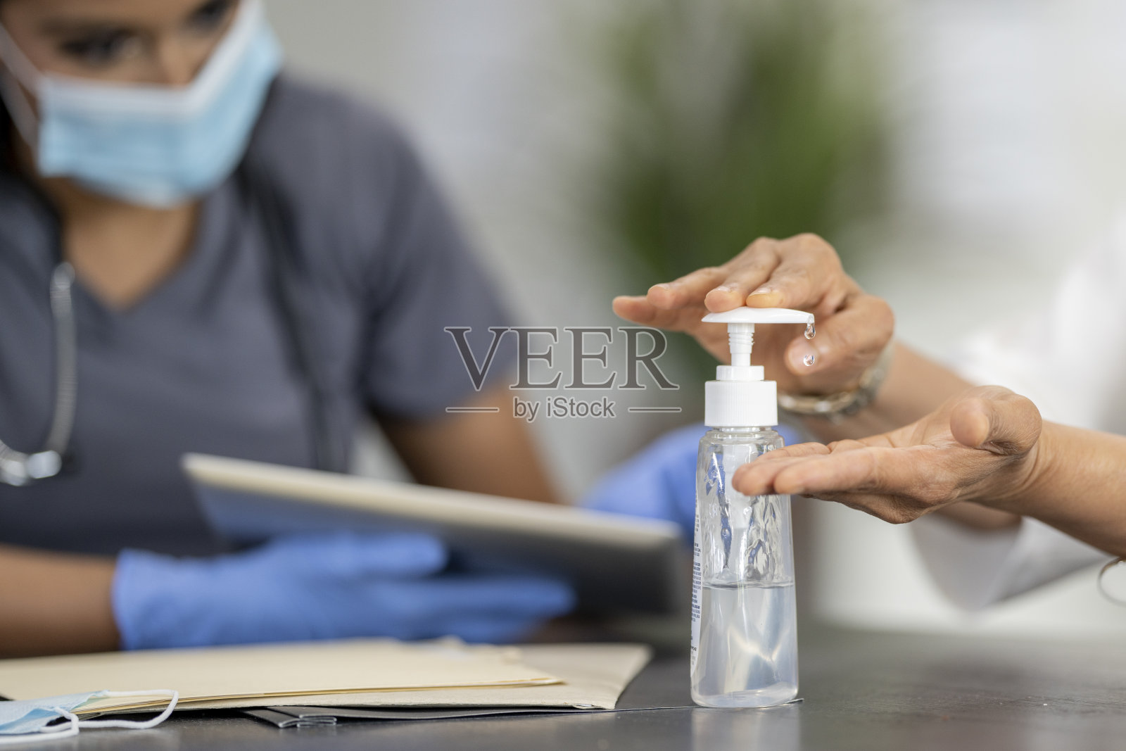 在蒙面医疗预约期间进行消毒照片摄影图片