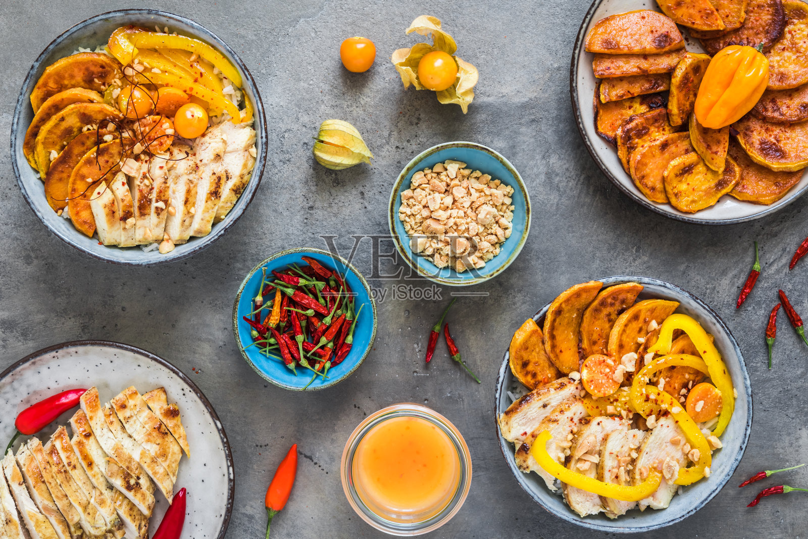 佛碗与辣鸡，米饭，甜椒，甘薯和花生碎，趋势和健康的食物，灰色背景俯视图照片摄影图片