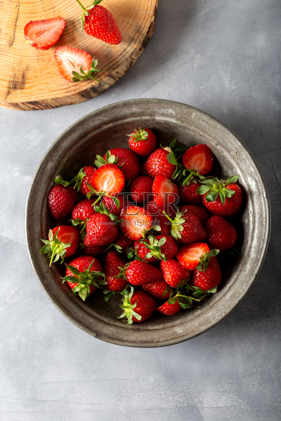 灰色背景的盘子里的新鲜草莓。前视图。照片摄影图片