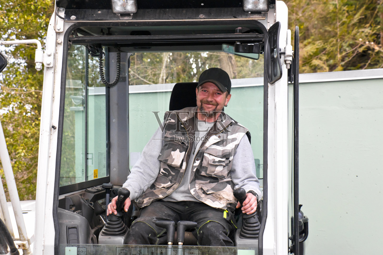 笑容可掬的挖掘机操作员在工作照片摄影图片