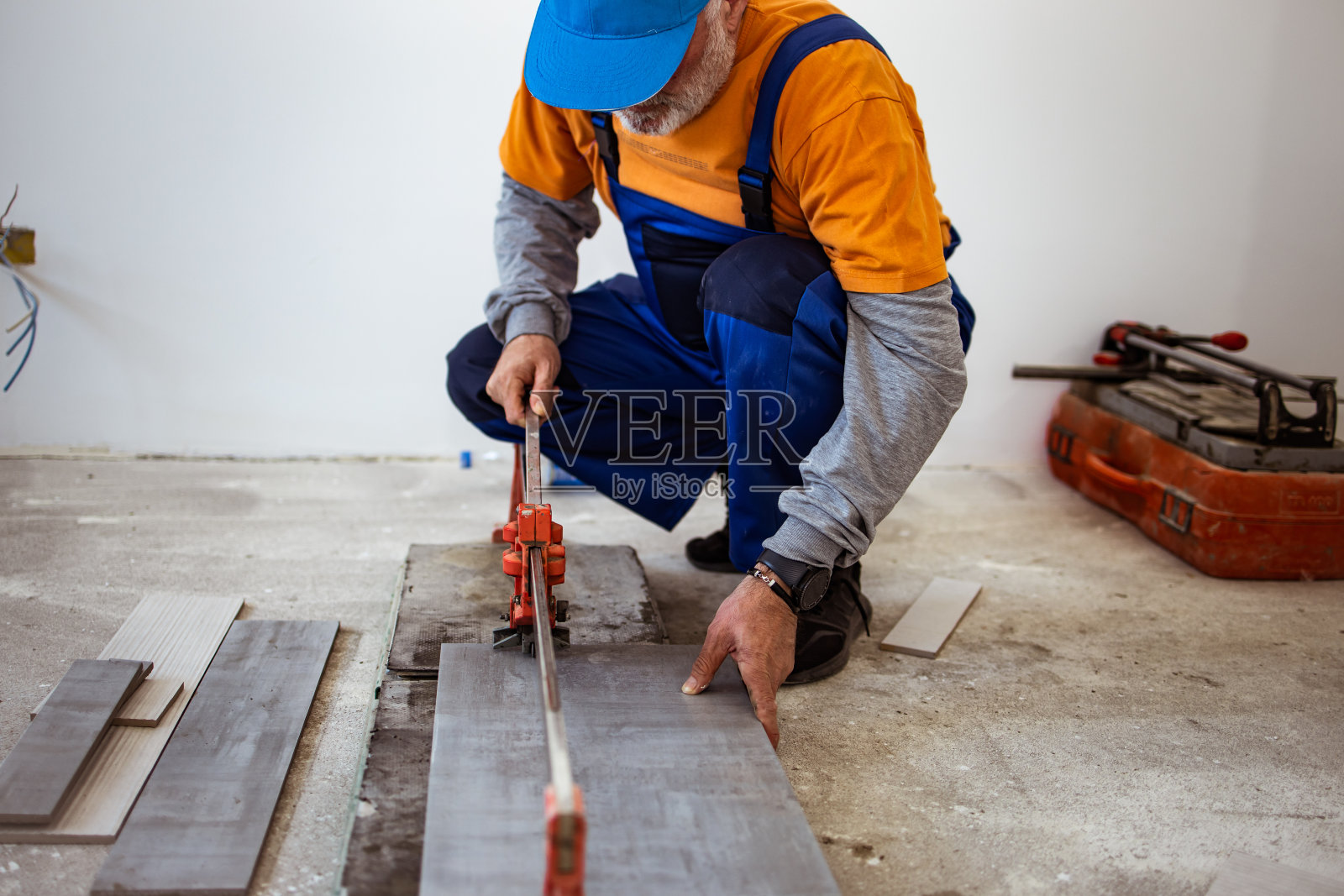 杂工在地板上切割仪式用的瓷砖照片摄影图片