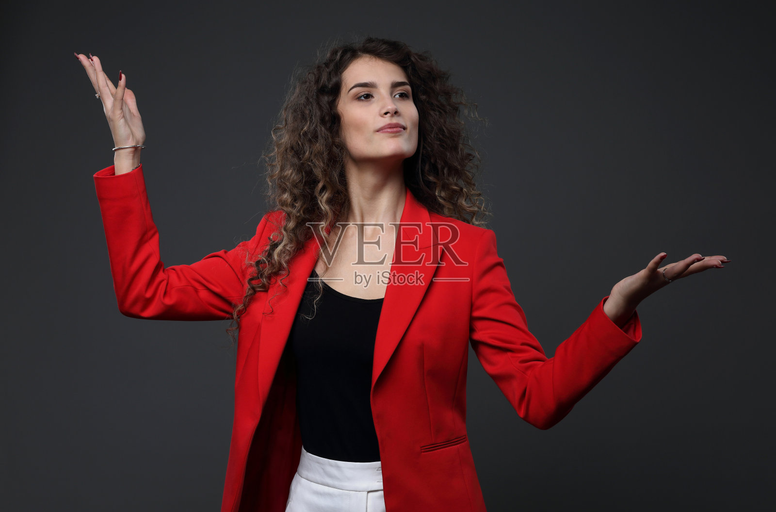 一个穿着红色夹克的漂亮女孩的肖像，背景是灰色的照片摄影图片