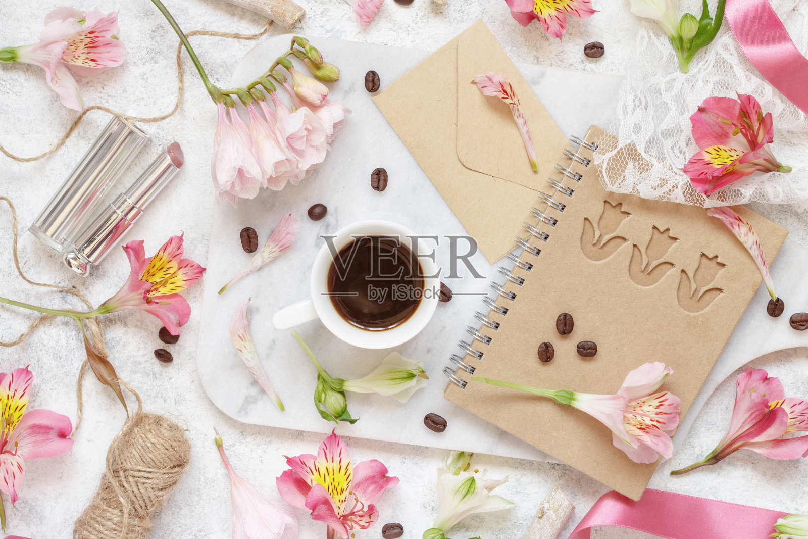 白色的桌子上放着咖啡和糖，桌上放着粉红色的花照片摄影图片