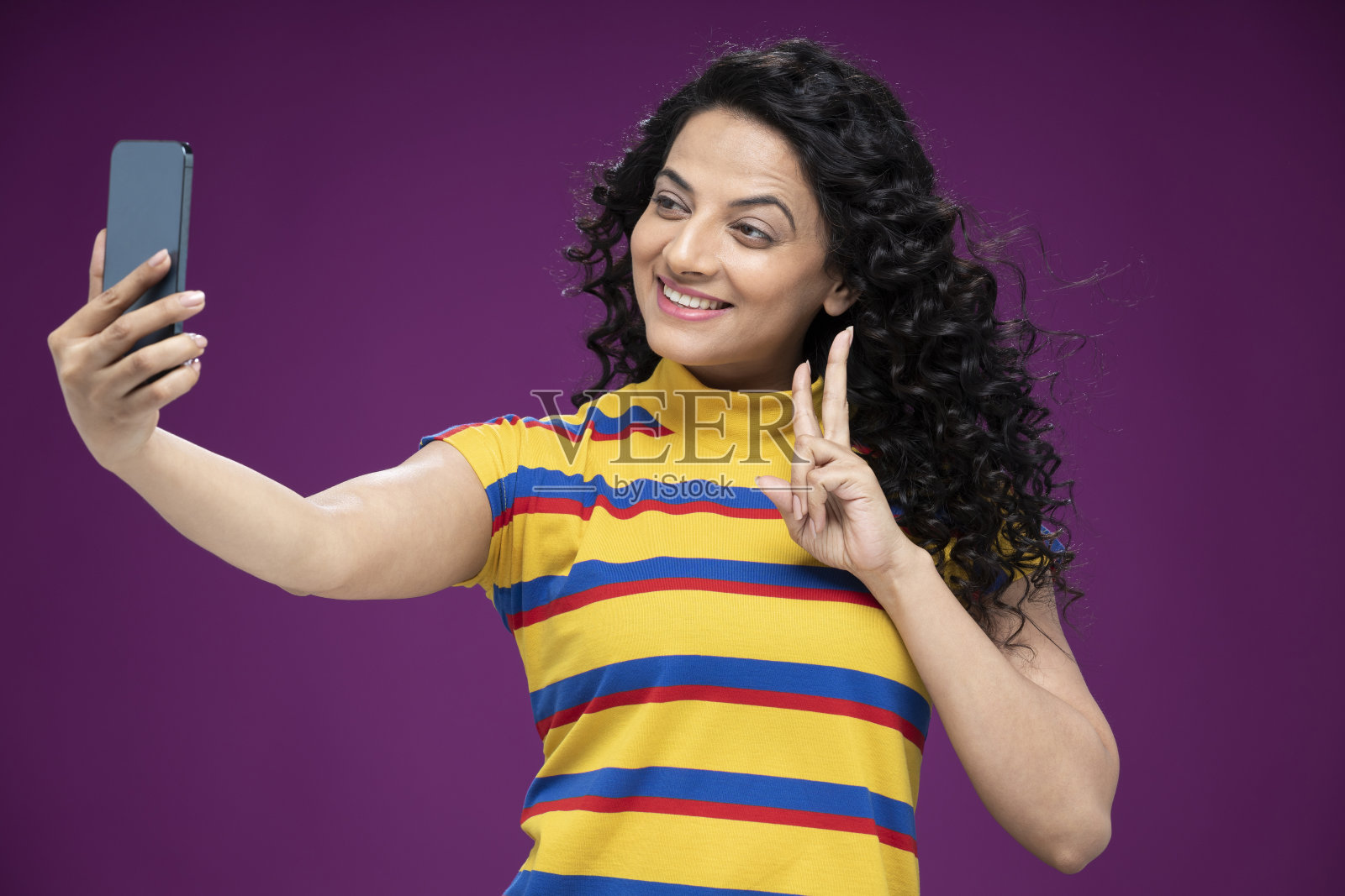 一个年轻女子站在孤立的紫色背景:-库存照片照片摄影图片