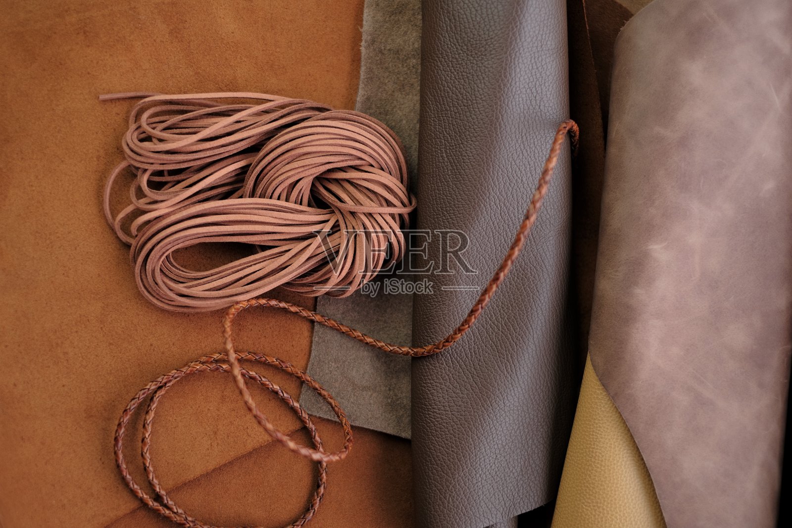 天然皮革背景上的皮革绳，皮革制品配件，皮革工业材料照片摄影图片