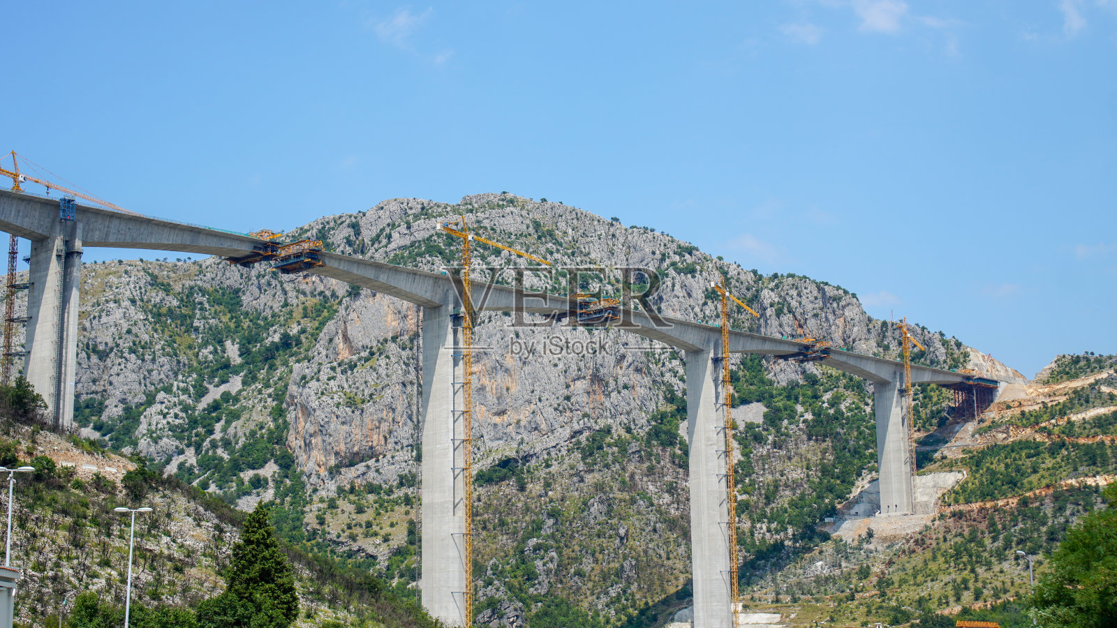 黑山莫拉卡峡谷新公路桥施工现场的高大起重机和混凝土柱照片摄影图片