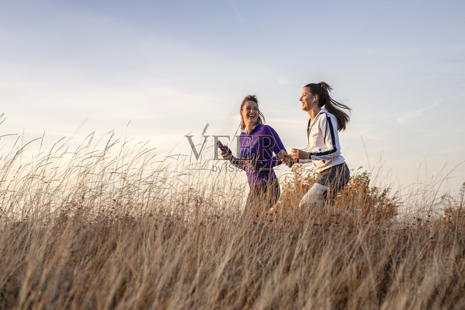 年轻快乐最好的女性朋友穿着运动服一起在大自然中慢跑照片摄影图片