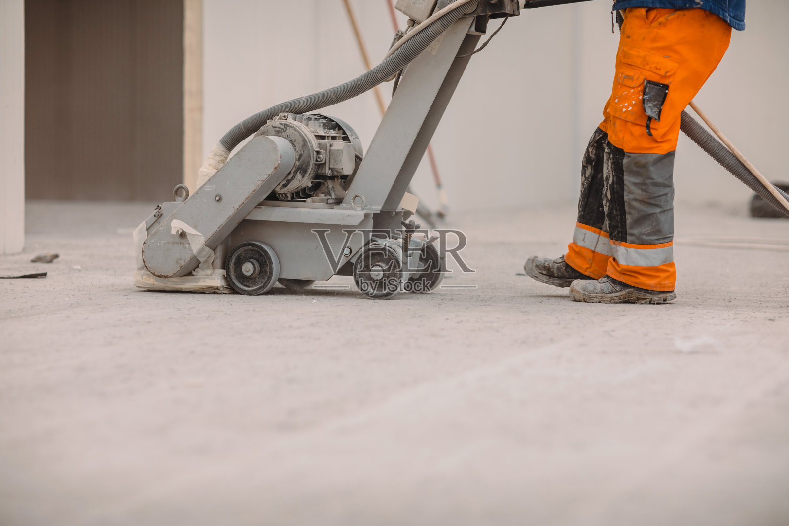 工人们在建筑工地打磨混凝土地板。为聚氨酯砂浆准备地板照片摄影图片