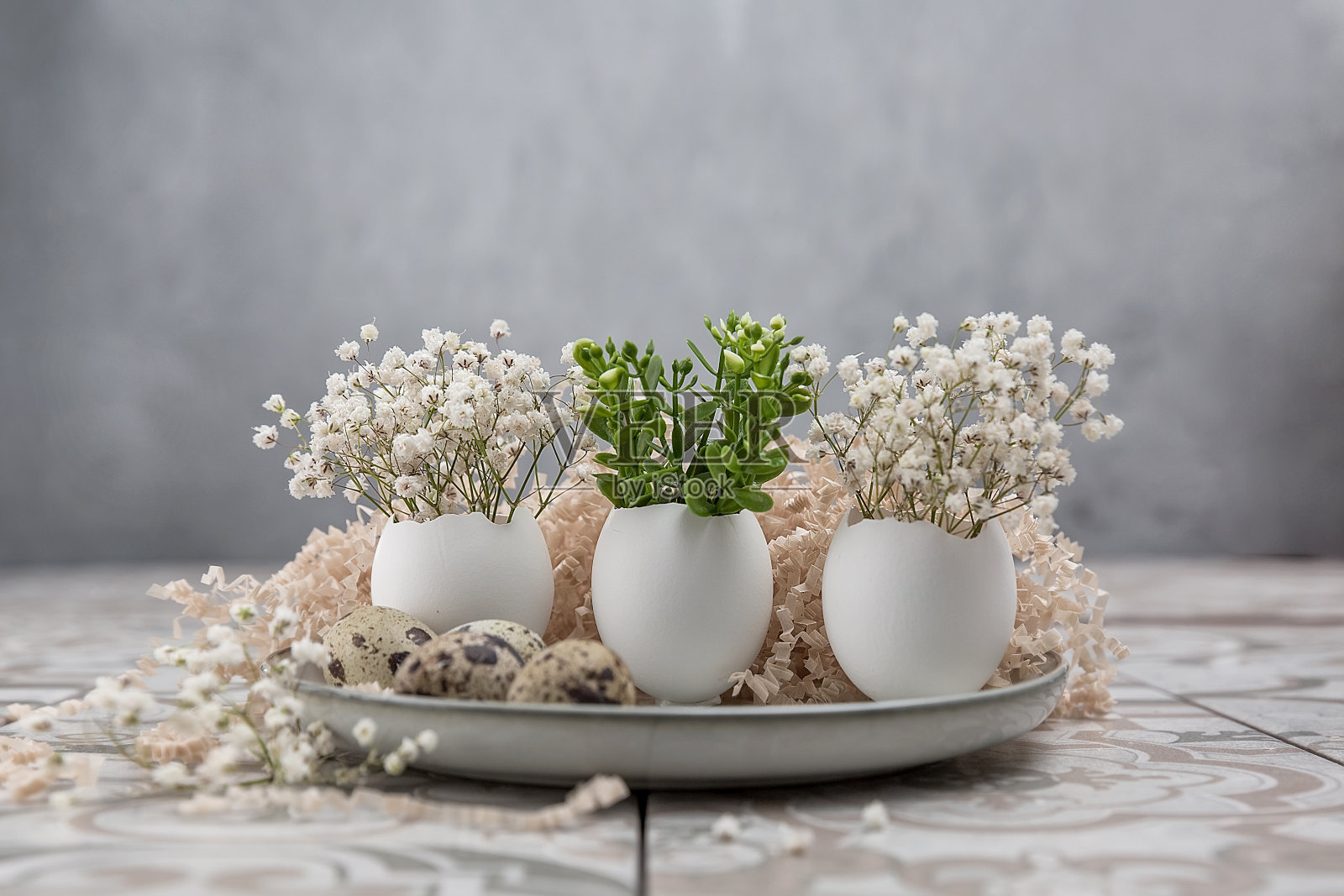 复活节组成。复活节彩蛋在盘子里。一个鸡蛋里的一小束花。复活节的最小概念。照片摄影图片