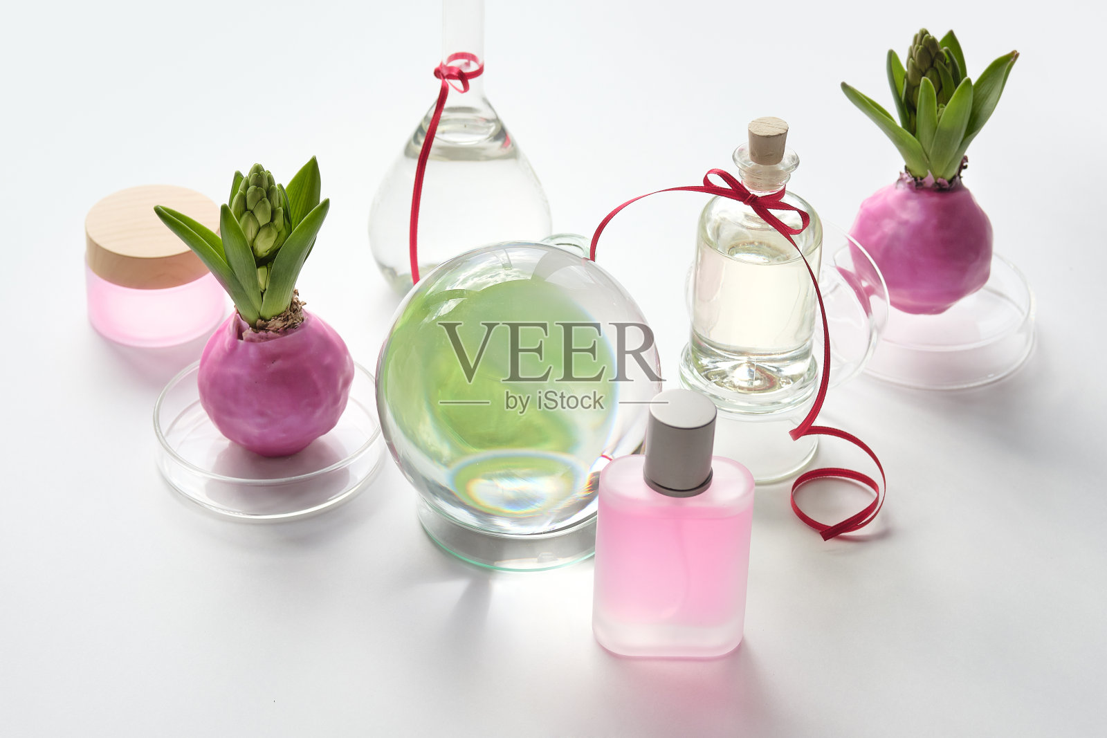 面部和身体护肤品，排列在白色的桌子上。面部护理产品，玻璃水晶球，风信子花球茎。护肤水、肥皂、精油、精华液照片摄影图片