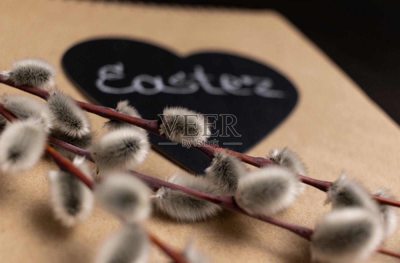 选择性聚焦柳树花特写和散焦复活节心的背景。照片摄影图片