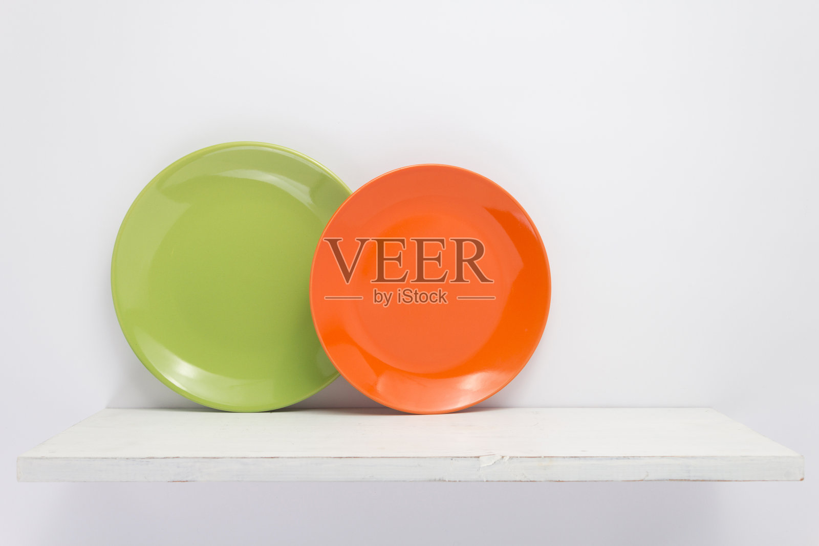 在墙上的木架上放置盘子和盘子。白底碗照片摄影图片