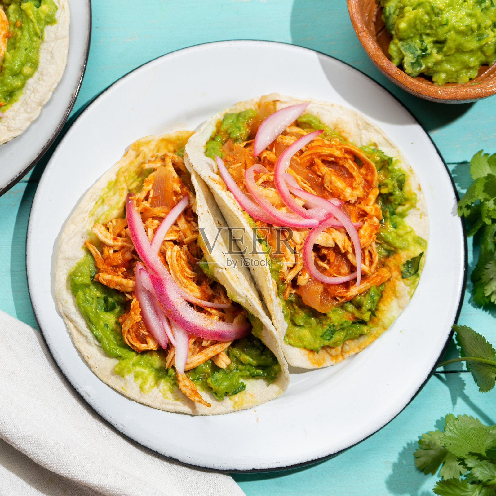 鸡肉玉米饼配鳄梨色拉酱和洋葱绿松石色背景。墨西哥食物照片摄影图片